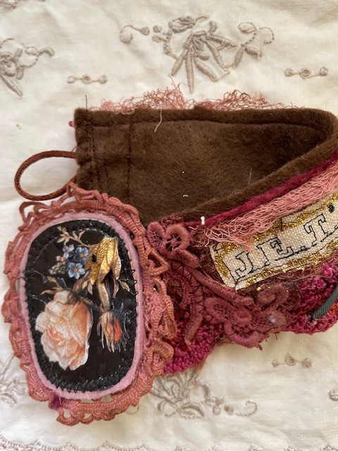 a fabric set of a cuff and pin,  embroidered and collage, flower pictures,