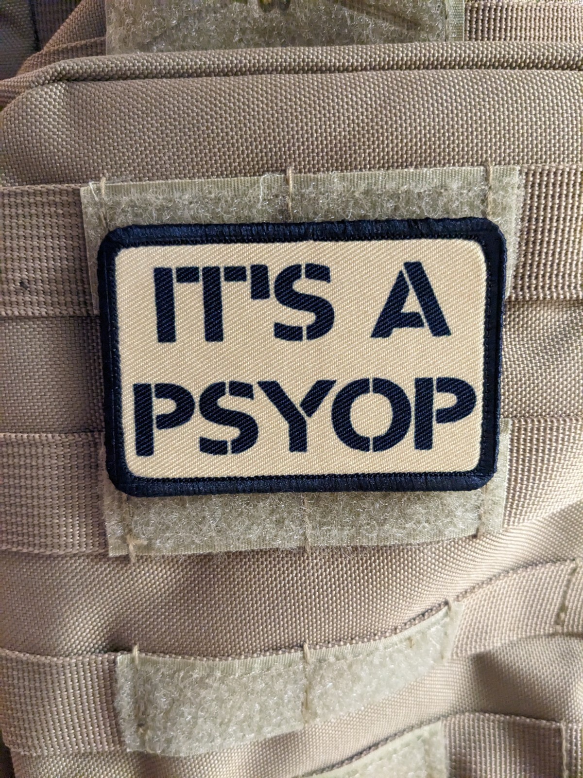 It's a Psyop conspiracy morale patch 2"x3" hook & loop tactical tan