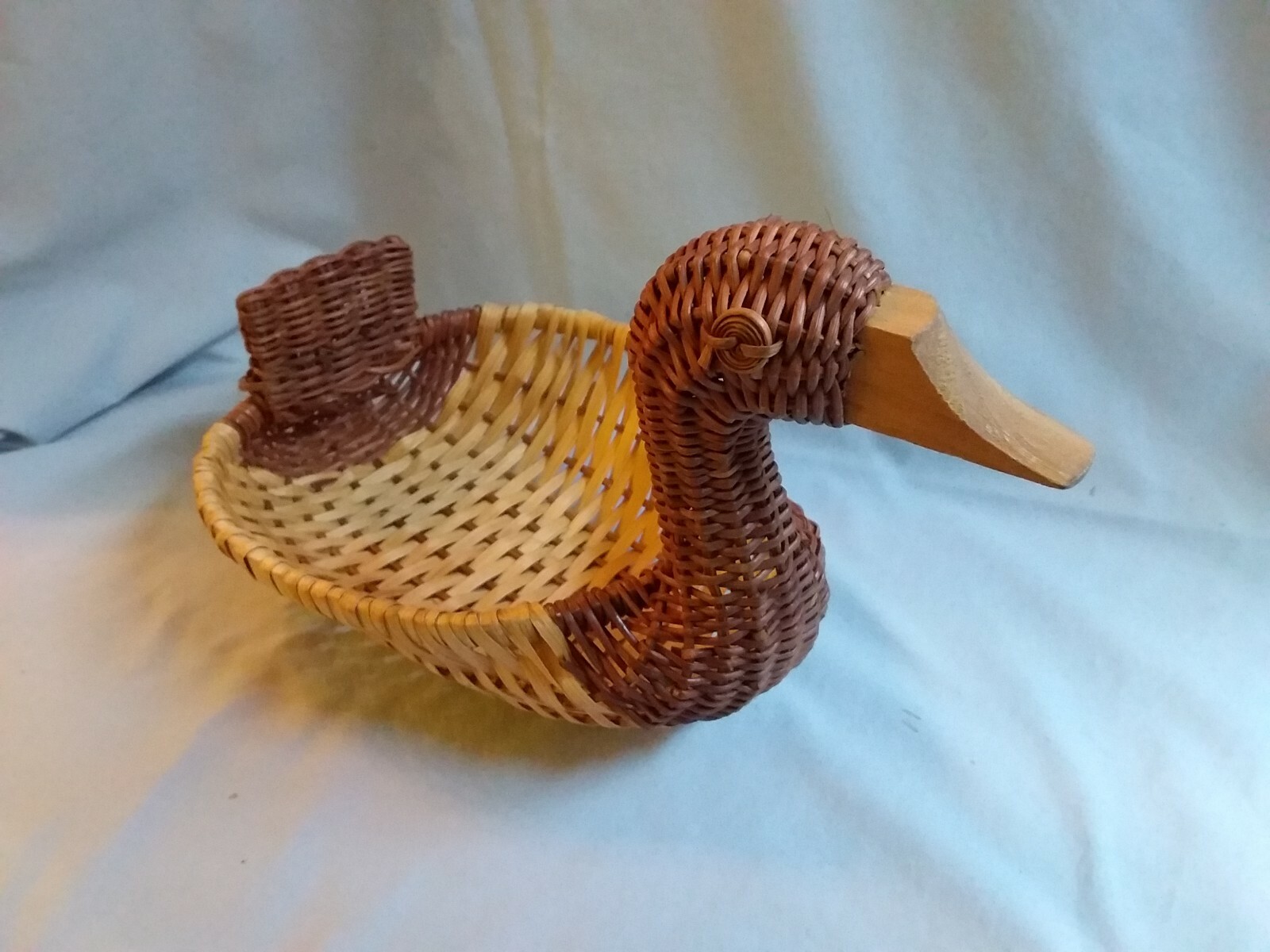 Woven straw basket shapped as a duck with a wooden beak