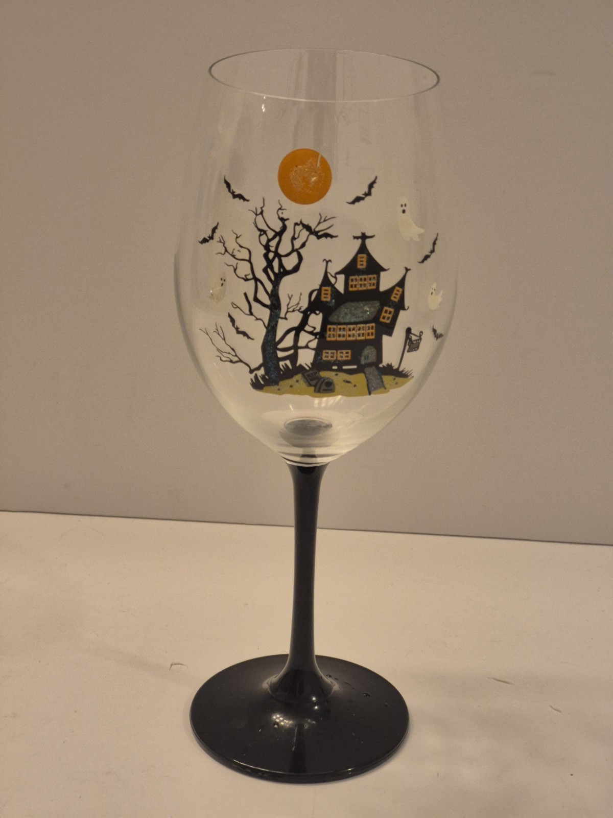 HALLOWEEN TALL WINE GLASS. HAUNTED HOUSE WITH GRAVEYARD. GLITTERED. SPOOKY