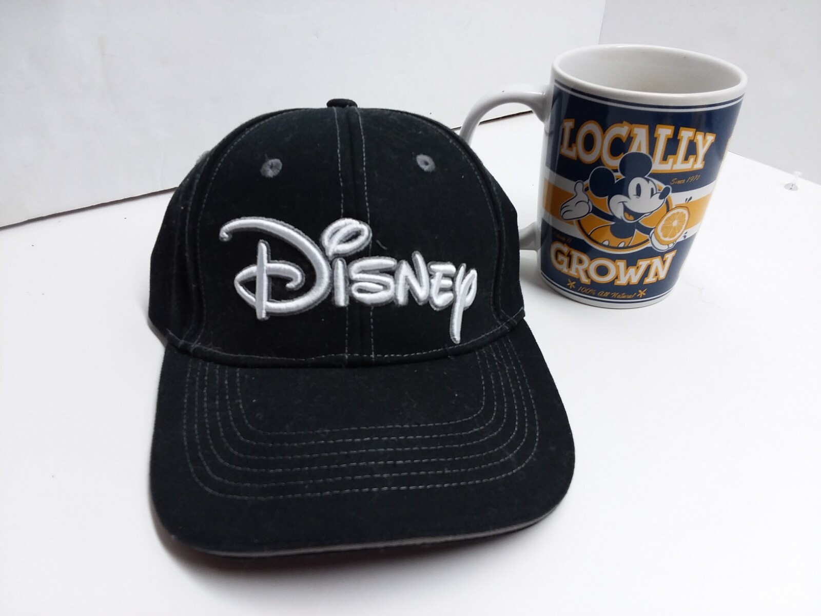 Disney baseball hat and a Mickey Mouse locally grown cup advertising OJ