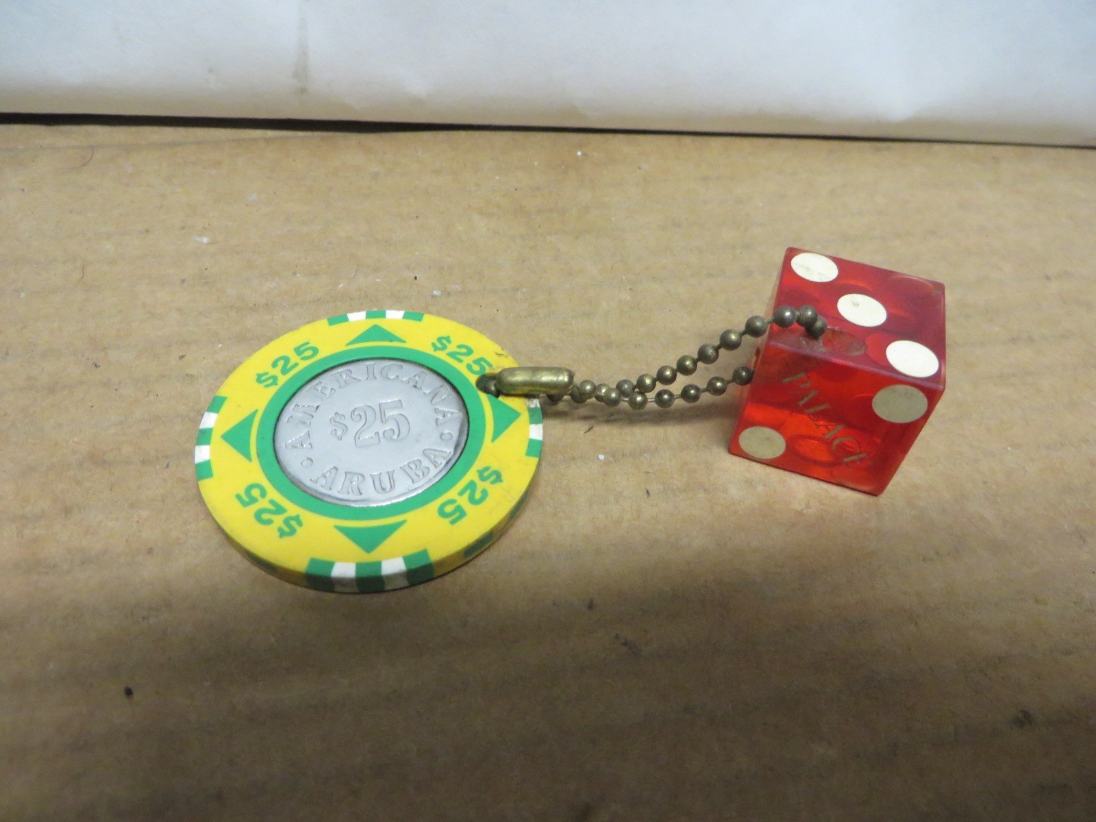 ARUBA AMERICANA 25$ SOUVENIR CASINO CHIP WITH CHAIN AND "PALACE 1146" RED DIE