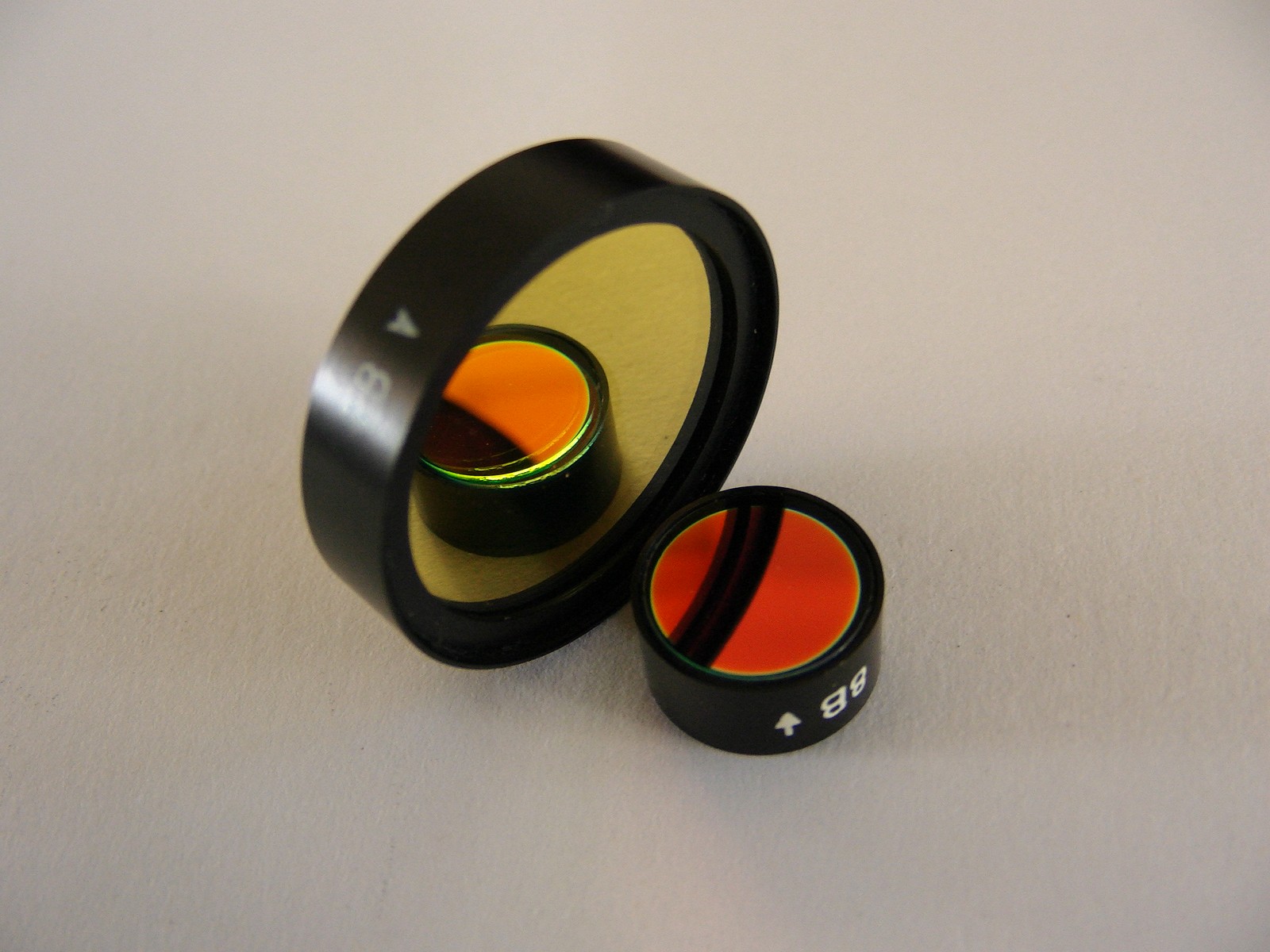 Coated narrow-band lenses for microplate reader fluorescence filter analyzer
