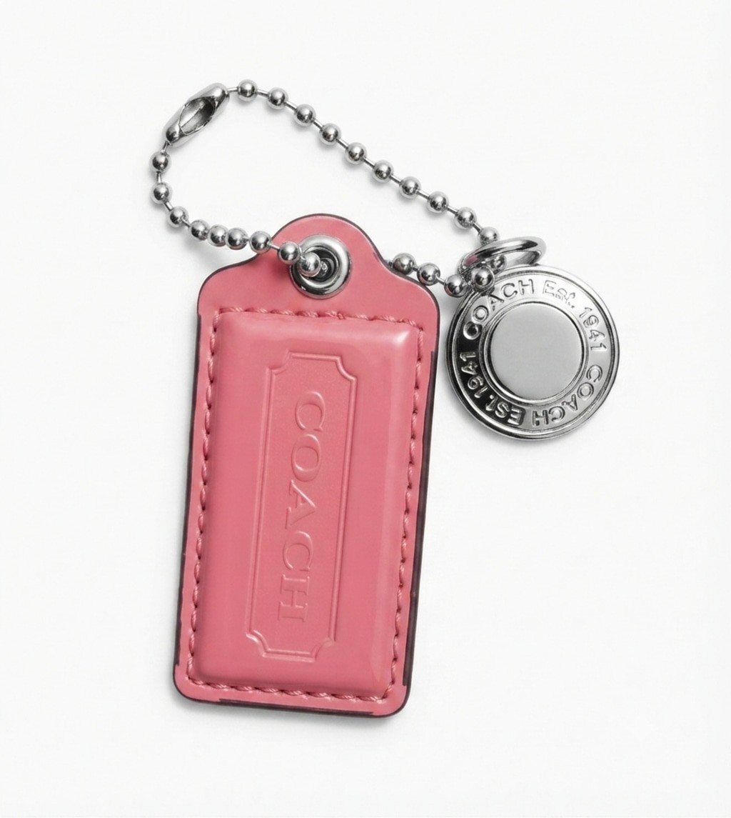 pink patent leather Coach hangtag bag charm and silver-nickel hardware charm.