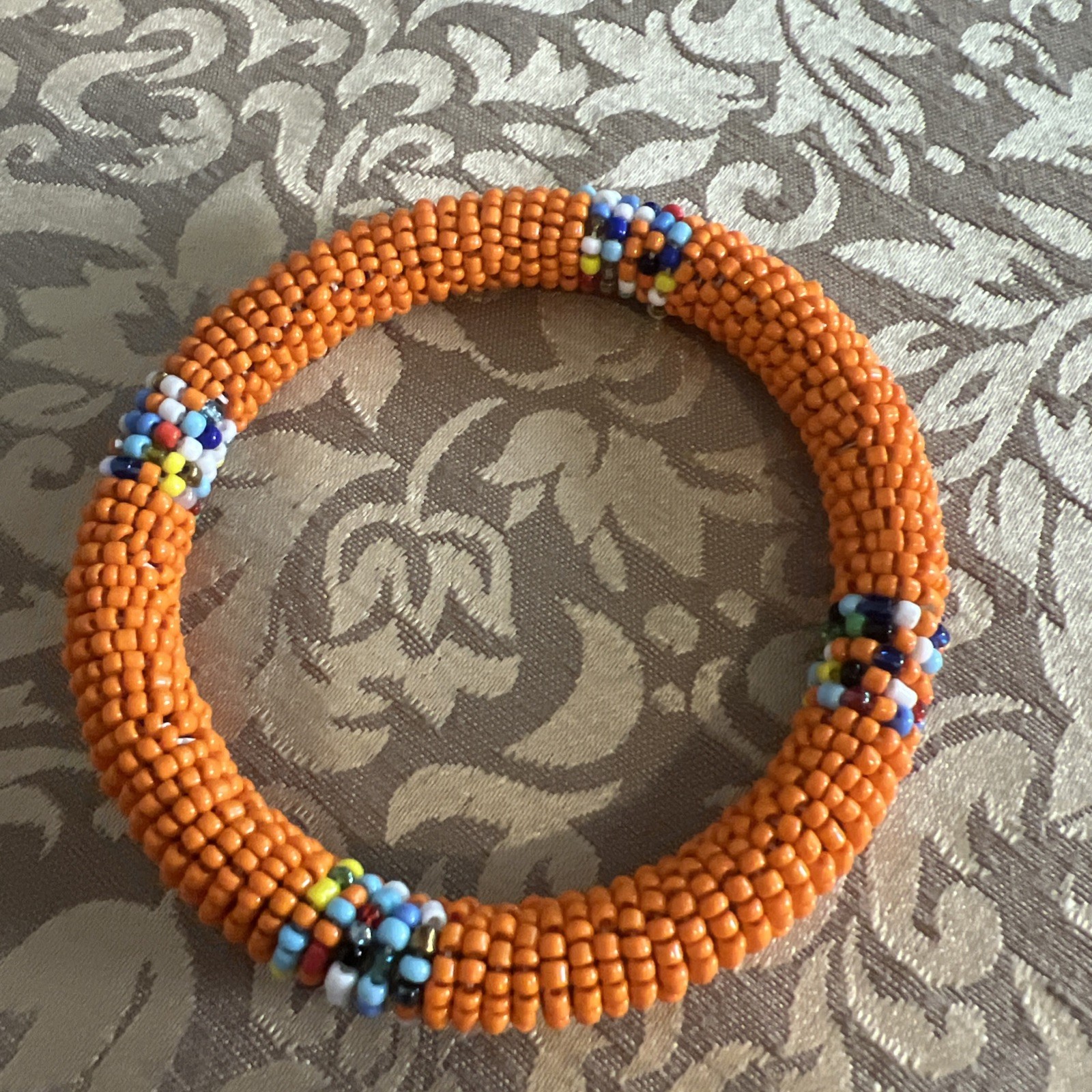 Beautiful Orange Beaded 7 Inch African Bracelet On Wood