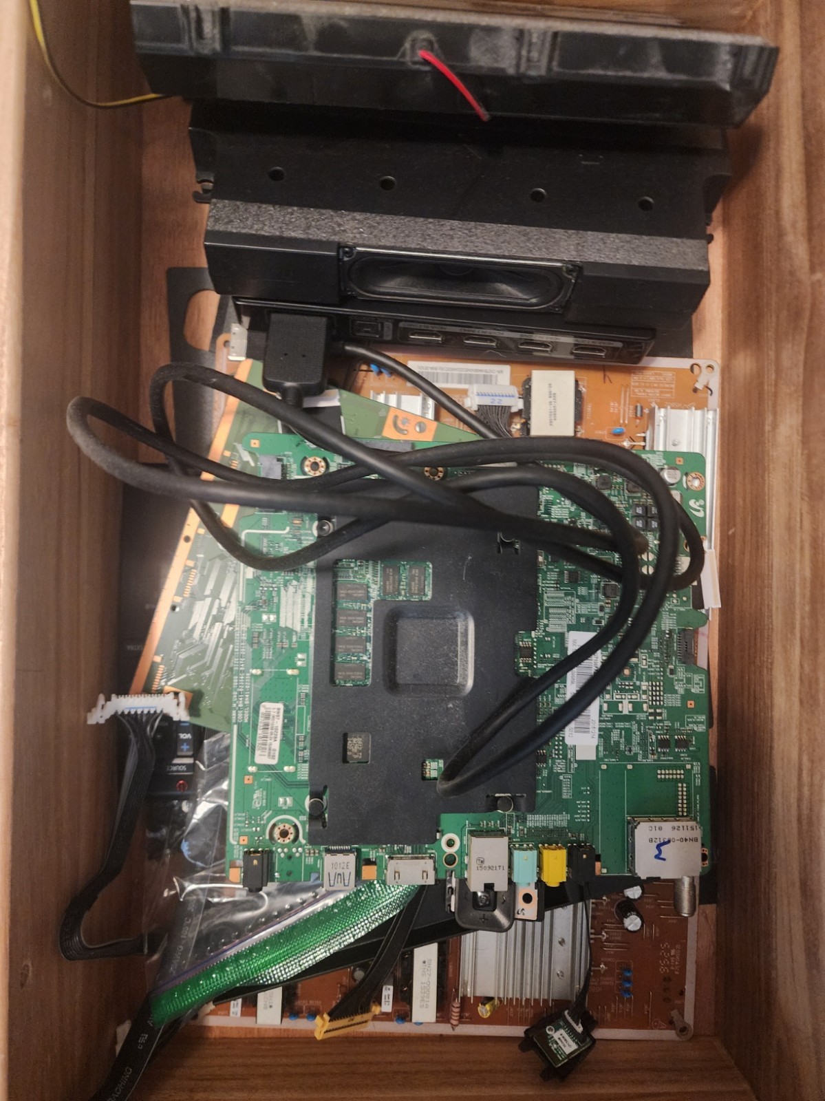 Box of parts for a Samsung TV, model UN55JU7100F, complete internal components