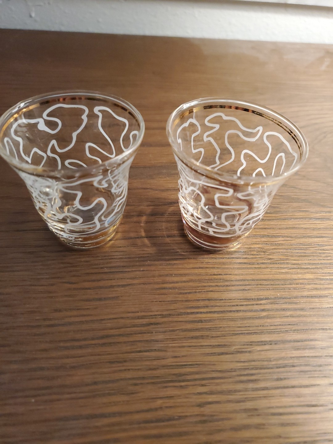2 Mid-Century Modern shot or liquor glasses gold trim. white abstract scroll...