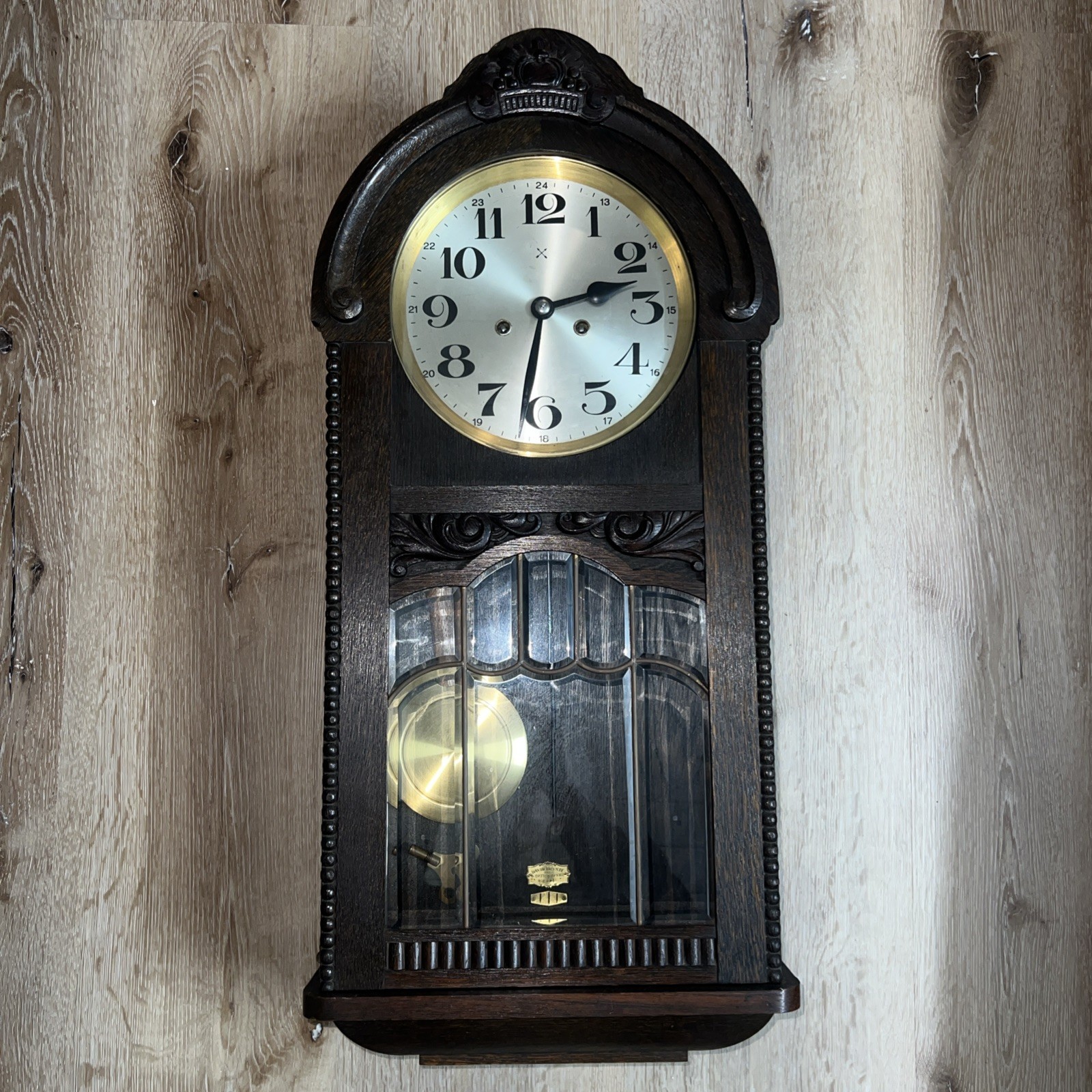 Antique German bell clock featuring a two-arrow logo.
