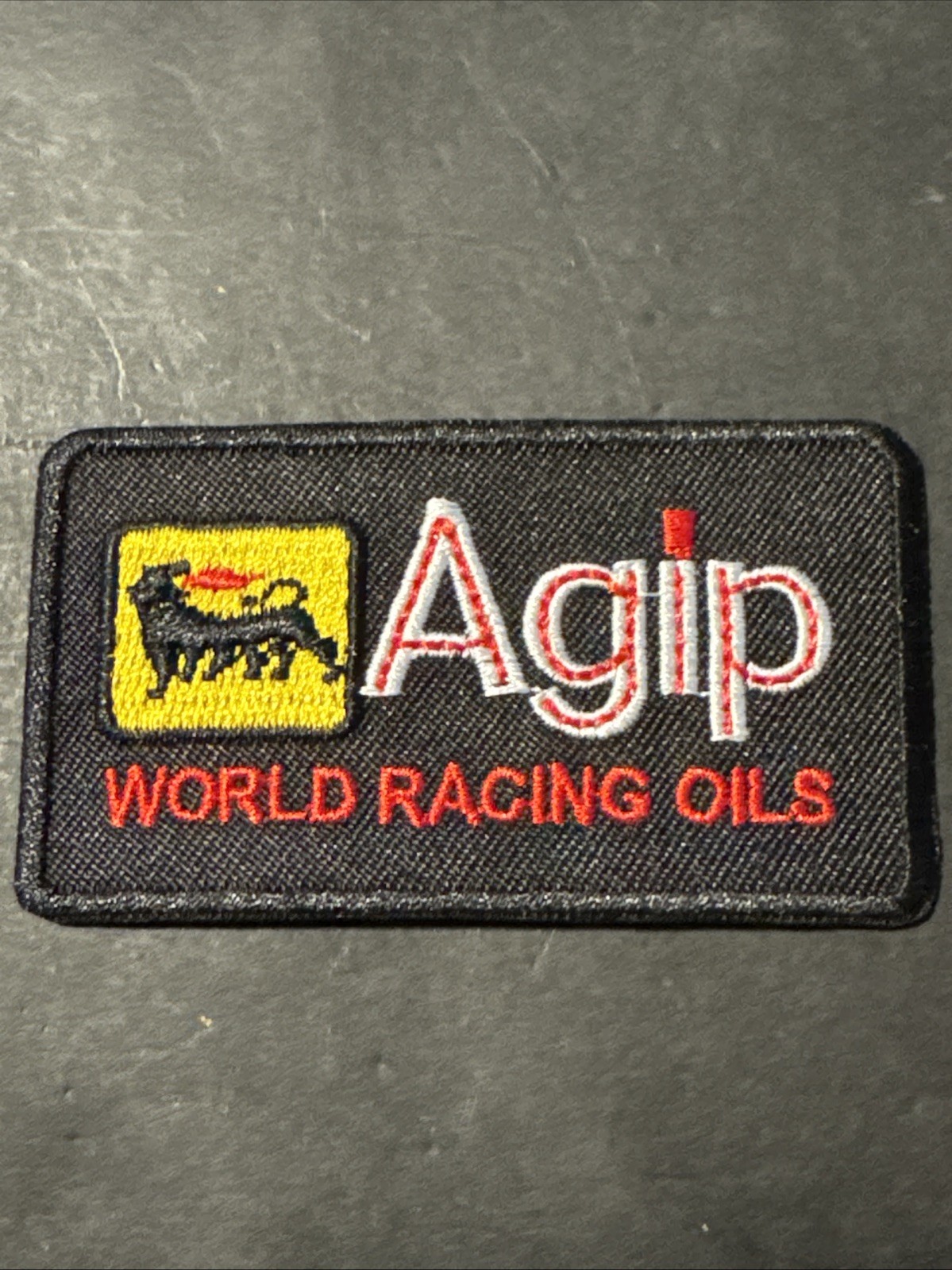 Black AGIP Motor Racing Fuels Oils Motorsport Sew / Iron On Patch