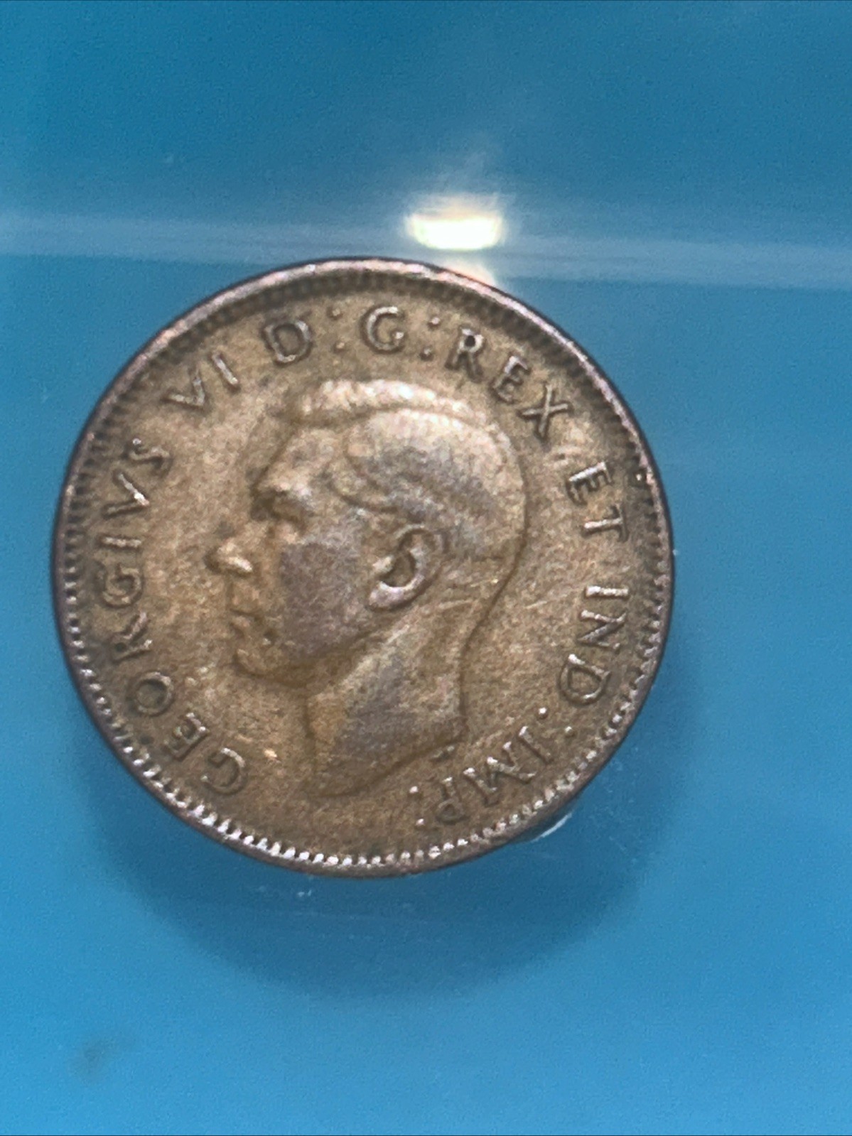 Canadian 1943 One Cent coin with a prominent maple leaf design on the reverse