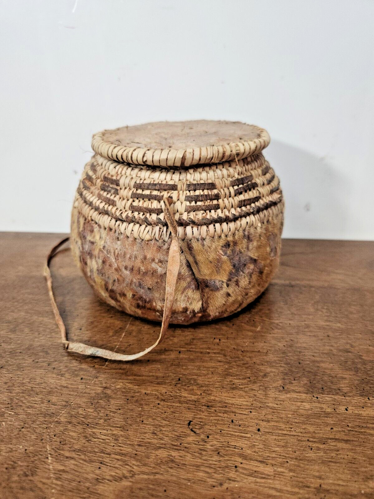 ANTIQUE OMANI BEDOUIN WOVEN LIDDED BASKET WITH LEATHER