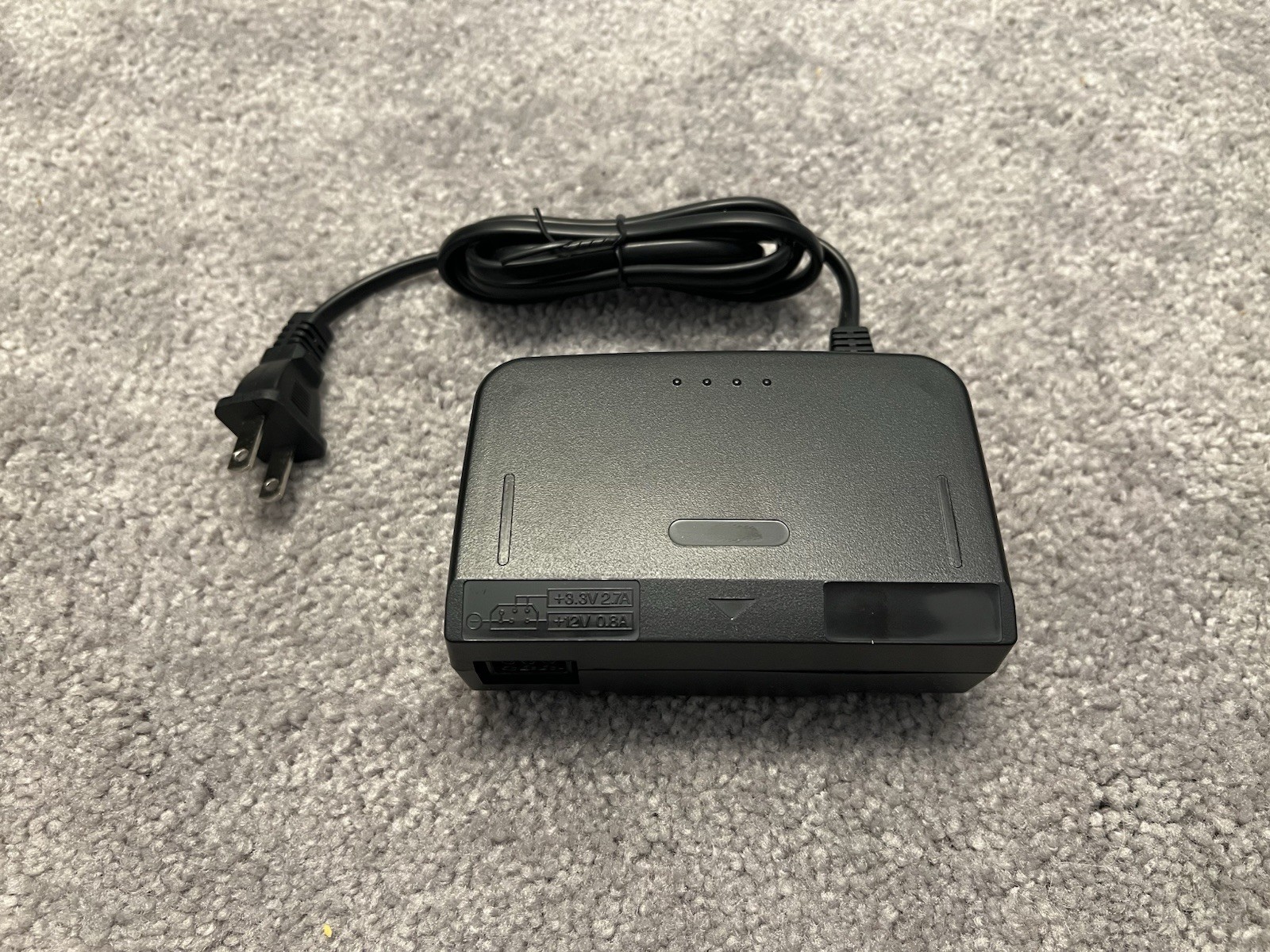 Nintendo 64 with black controller, AV cables, and power supply.