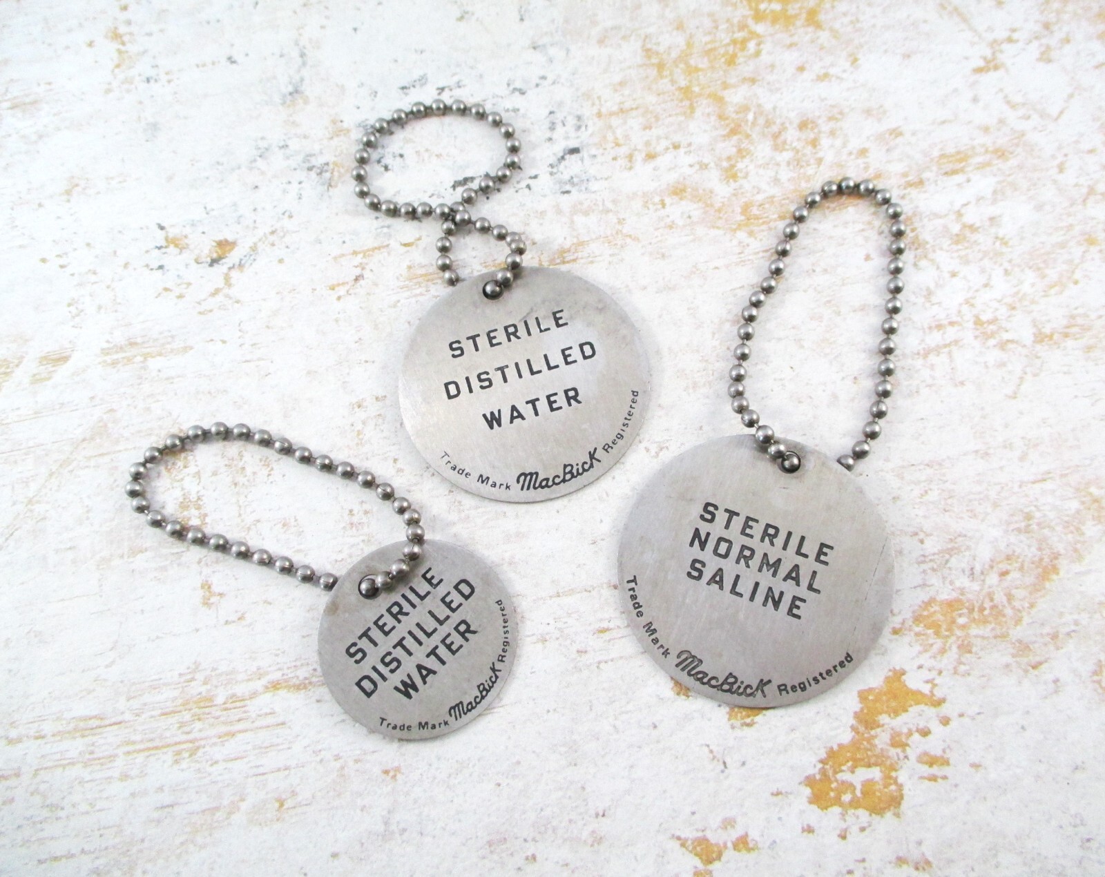 Three Vintage Aluminum MacBick Laboratory Water Tags