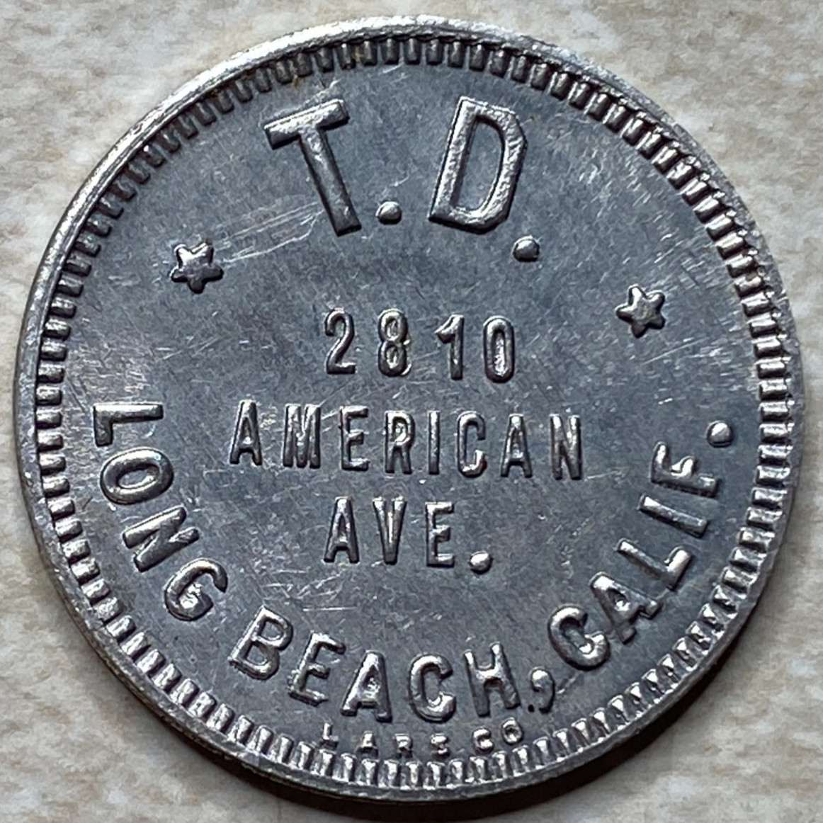 T9043 T.D. 2810 American Ave. Long Beach, CA  Anillo Restrike Arcade Token