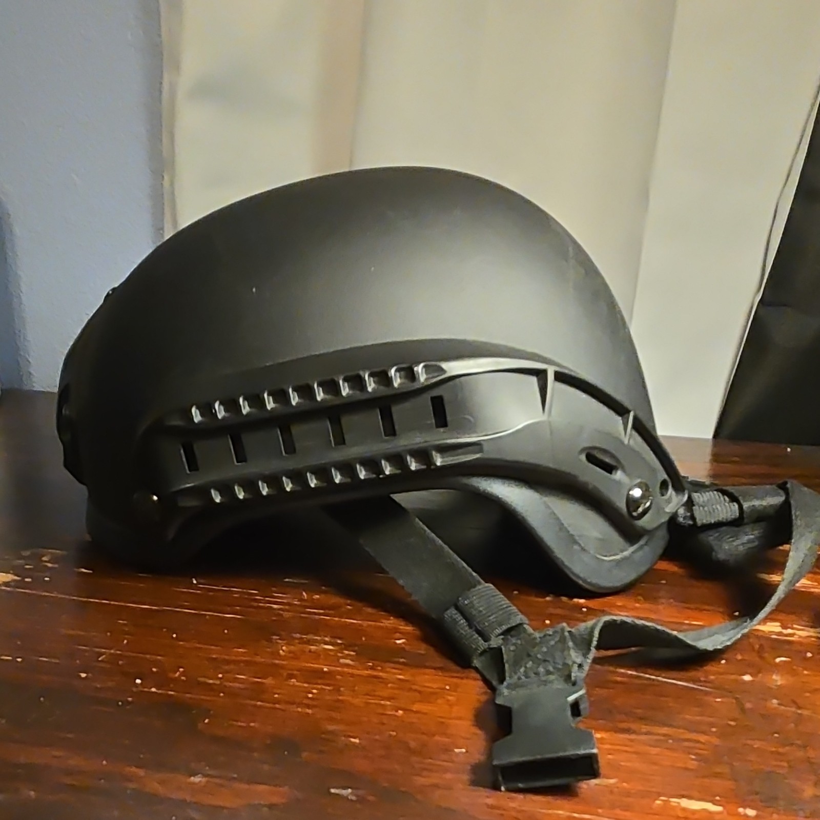 Black AIRSOFT helmet with rails for attaching headphones or flashlights.