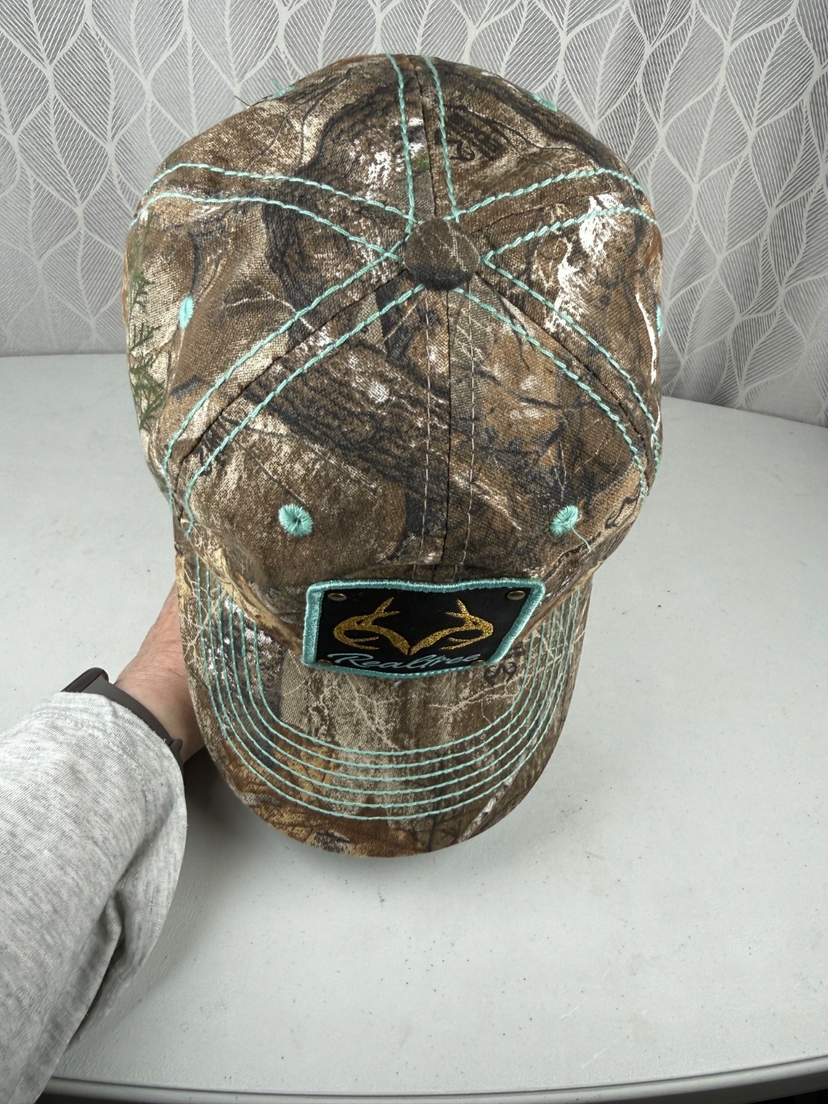Real Tree Gold Sparkle Logo Black Aqua Rivet Patch on Camouflage Hat Cap