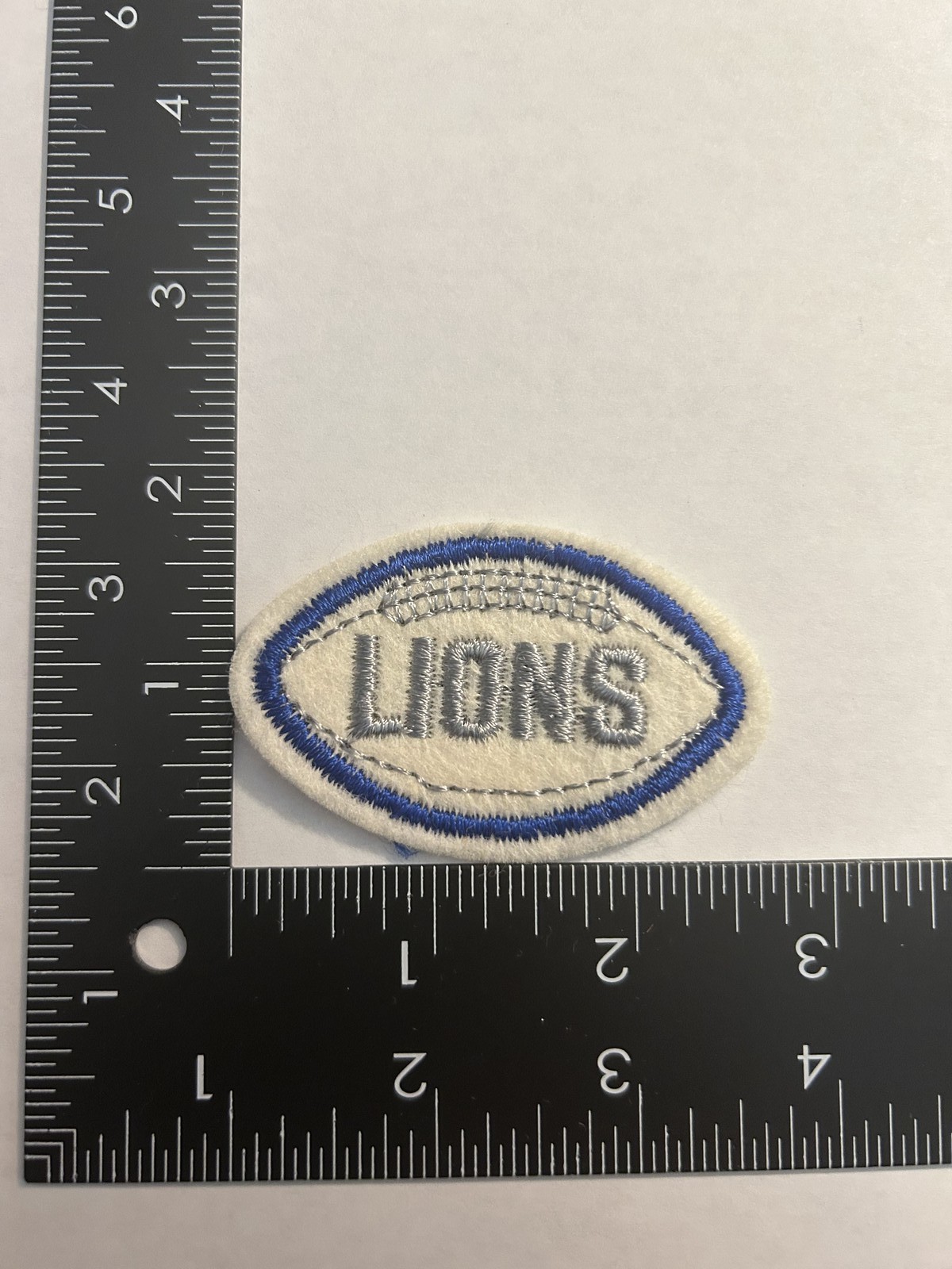 1970s VINTAGE NFL FOOTBALL SHAPED 2.75" PATCH LIONS SILVER TEXT BLUE FOOTBALL