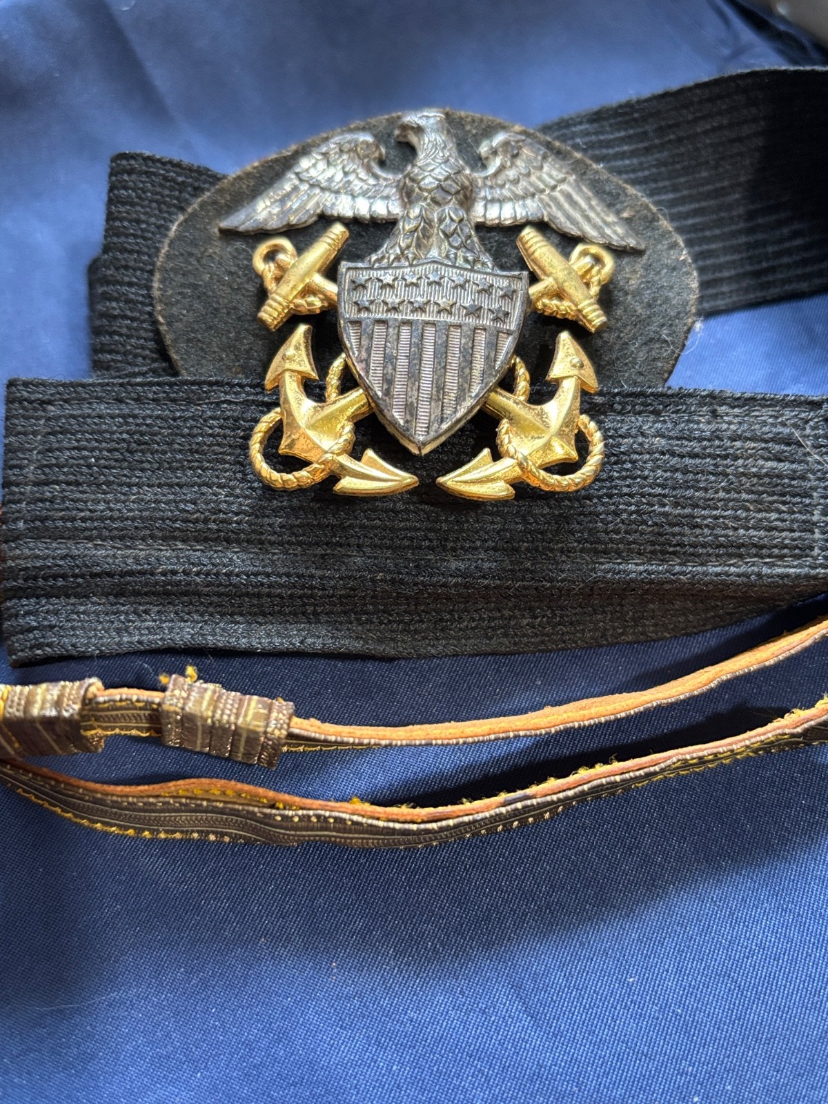 United States Navy cap badge on hat band with gold braid visor strap