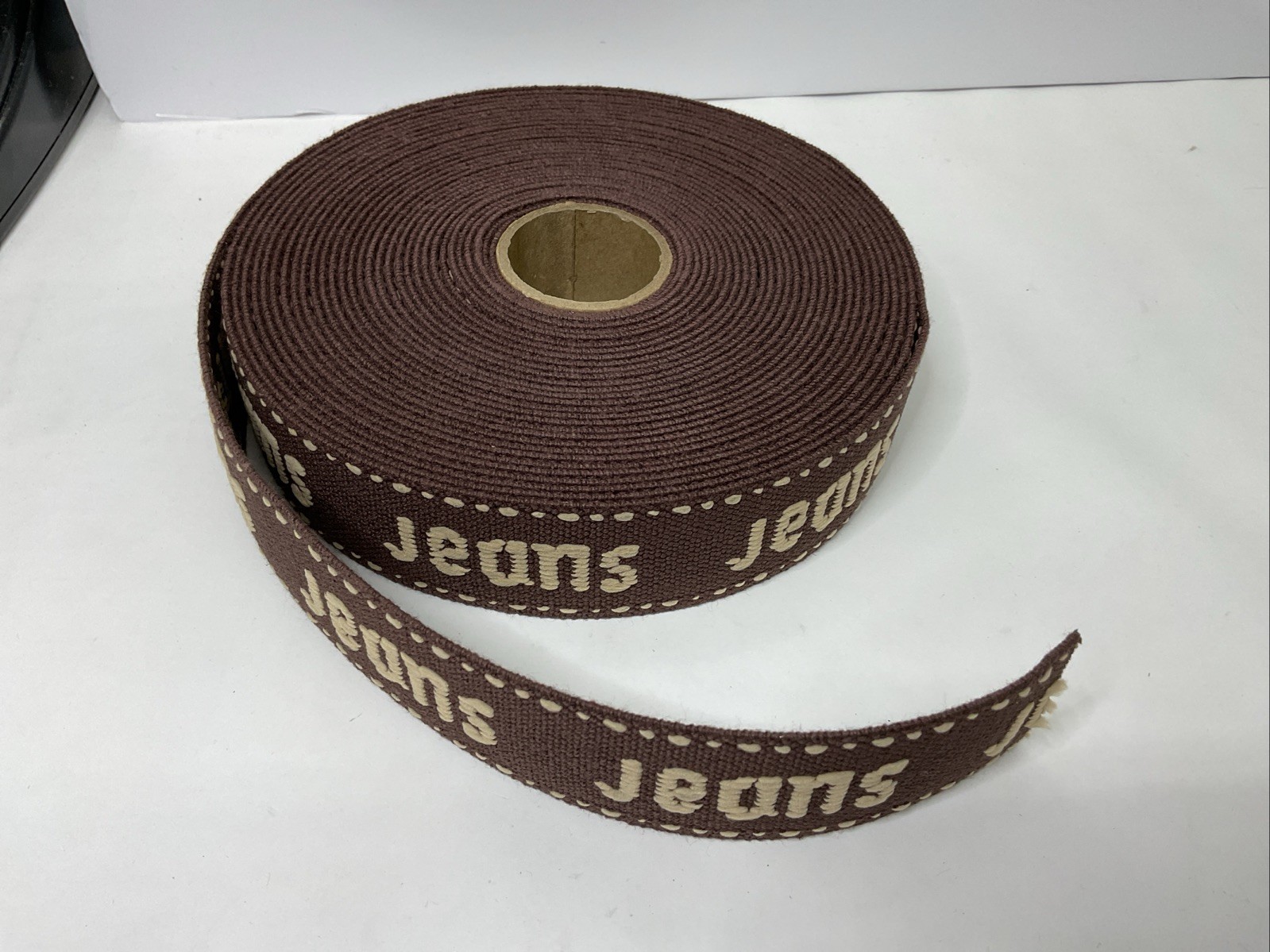 Belt Webbing White Embroidered ‘Jeans’ On Brown 1-1/2” X 10 Yards EW5