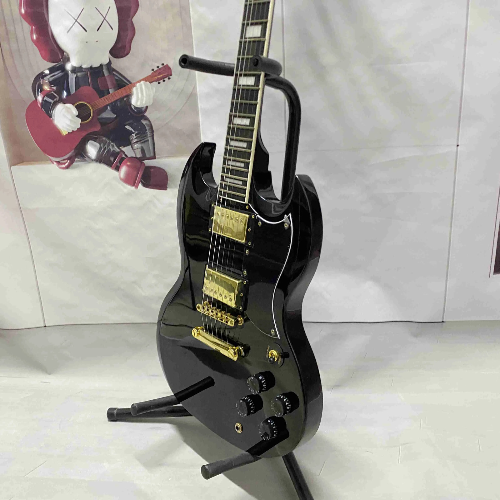 Black 6-string electric guitar with HH pickup, gold hardware, solid body
