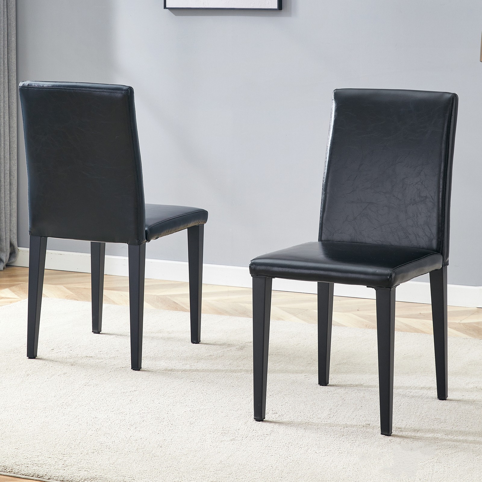 Two black PU dining chairs, simple and versatile, comfortable and accompanied.