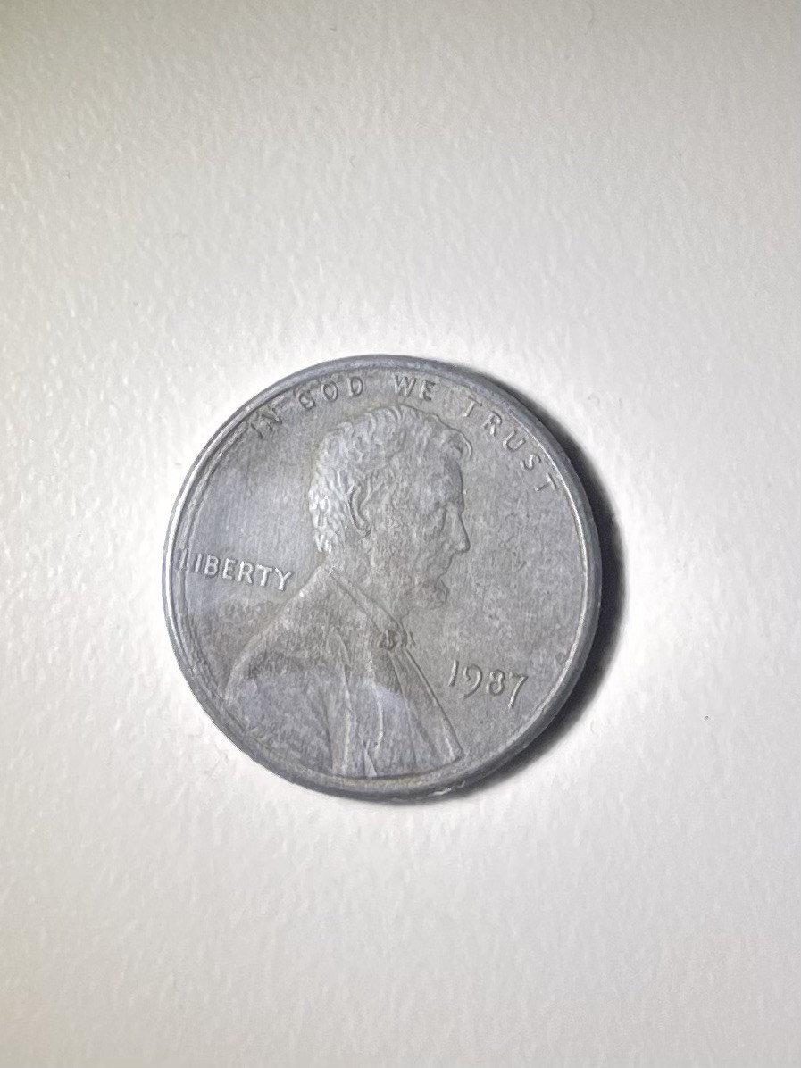 1987 Penny Unplated Planchet. coin that is lacking the copper layer or zinc