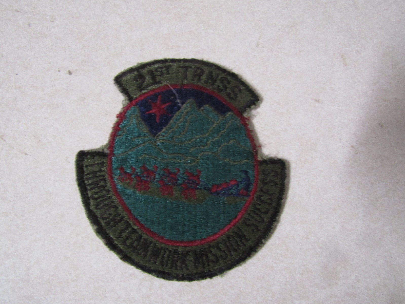 MILITARY PATCH SEW ON OLDER 21ST TRNSS THROUGH TEAMWORK MISSION SUCCESS