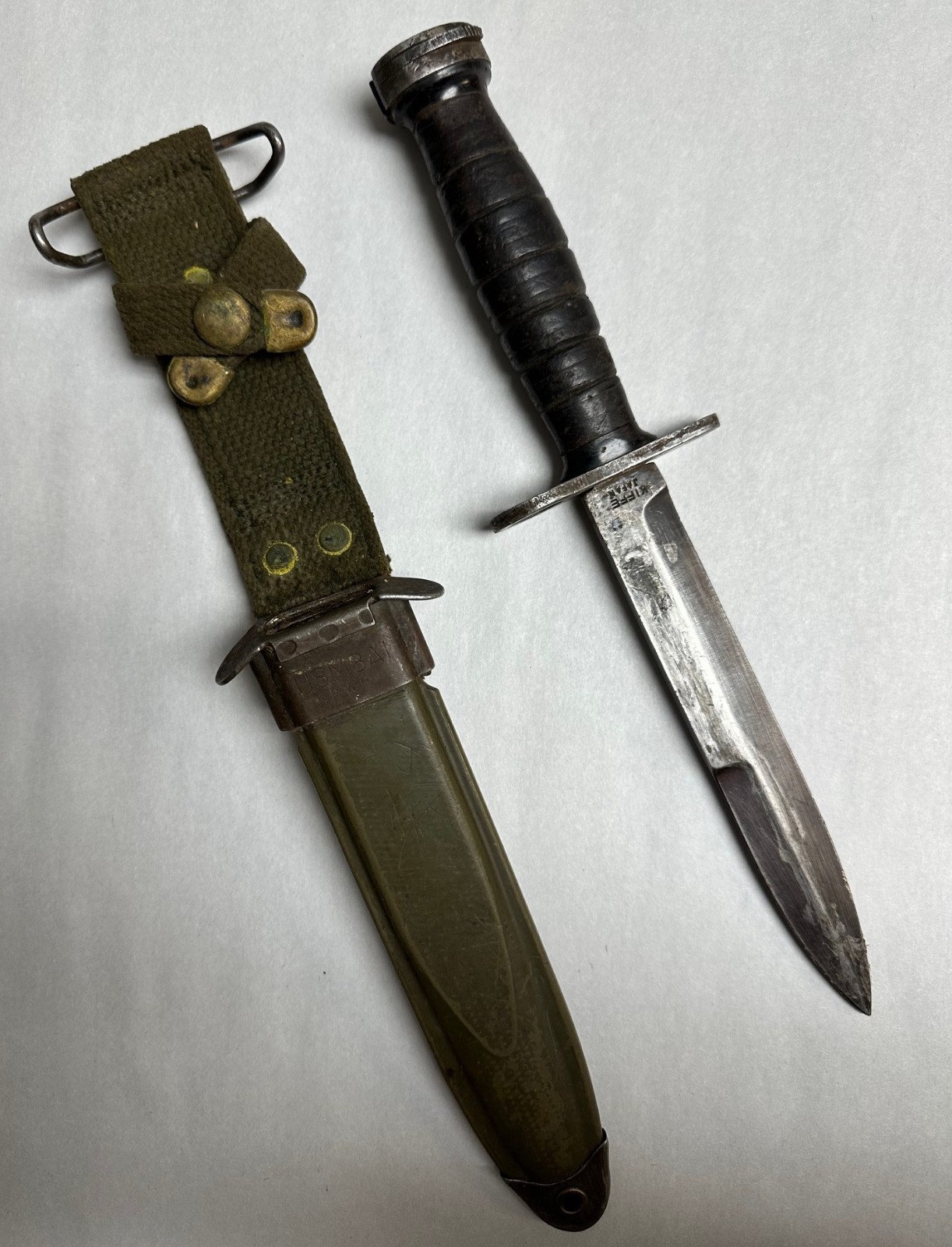 M1 CARBINE  BAYONET MARKED "KIFFE JAPAN" LEATHER HANDLE WITH SCABBARD.