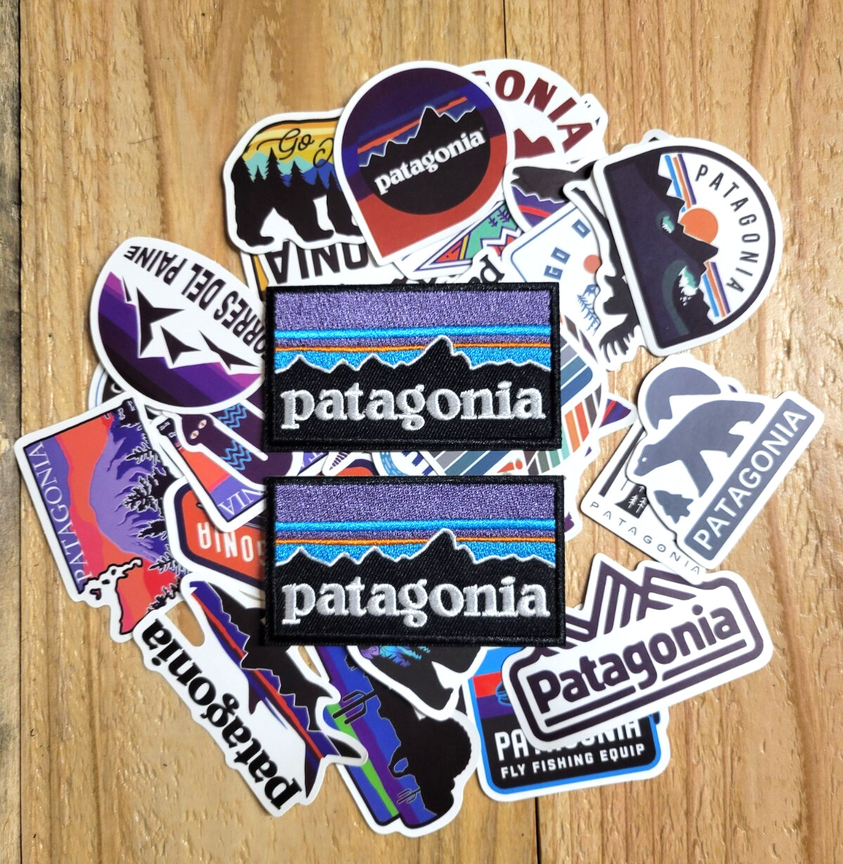 (2) Patagoni iron on replacement patches & pile of stickers (North Face, REI)