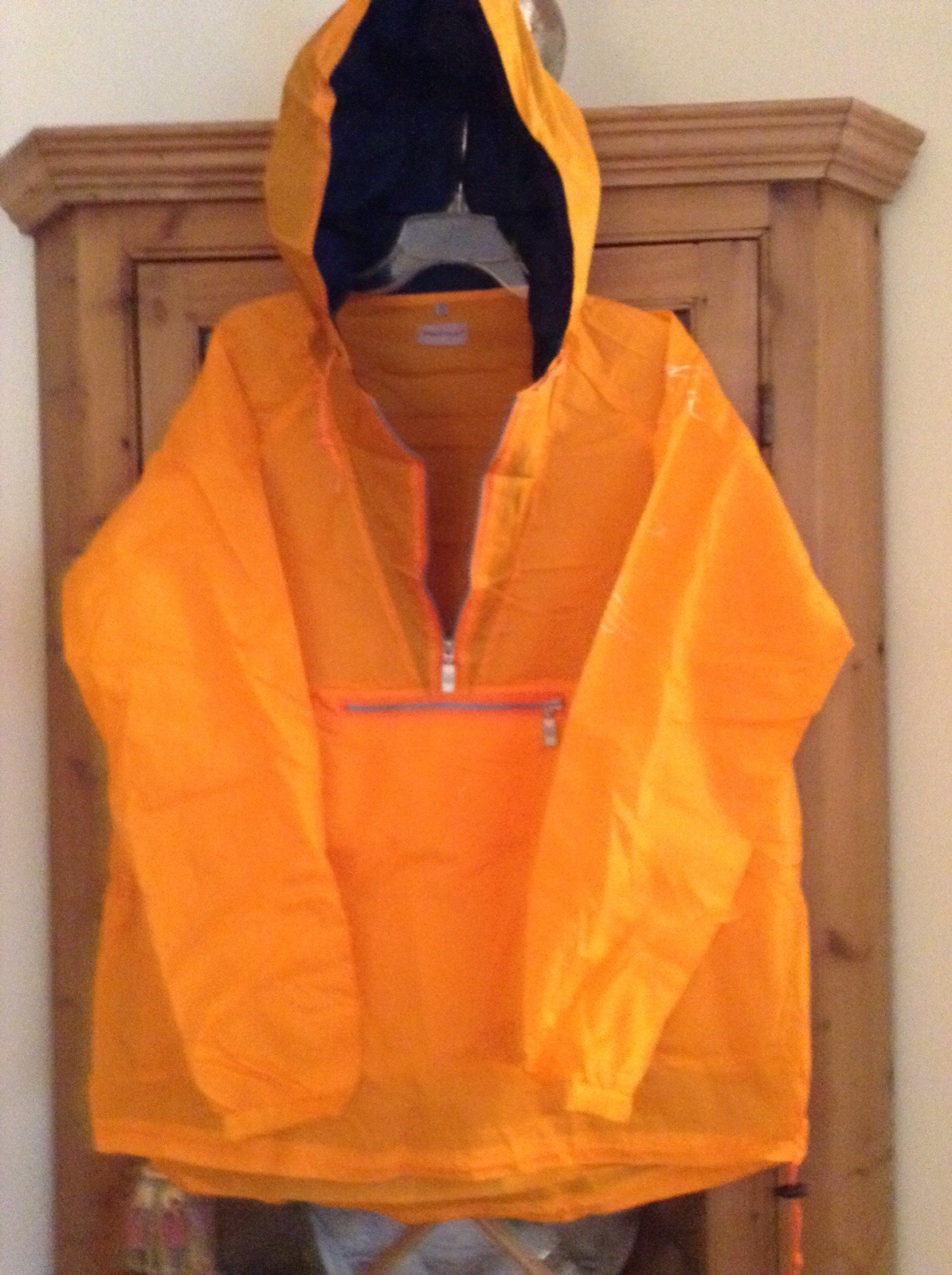 TAG HEUER ORANGE RAIN SLICKER HAS POCKETS, HOOD AND FOLDS INTO  ITS OWN POUCH