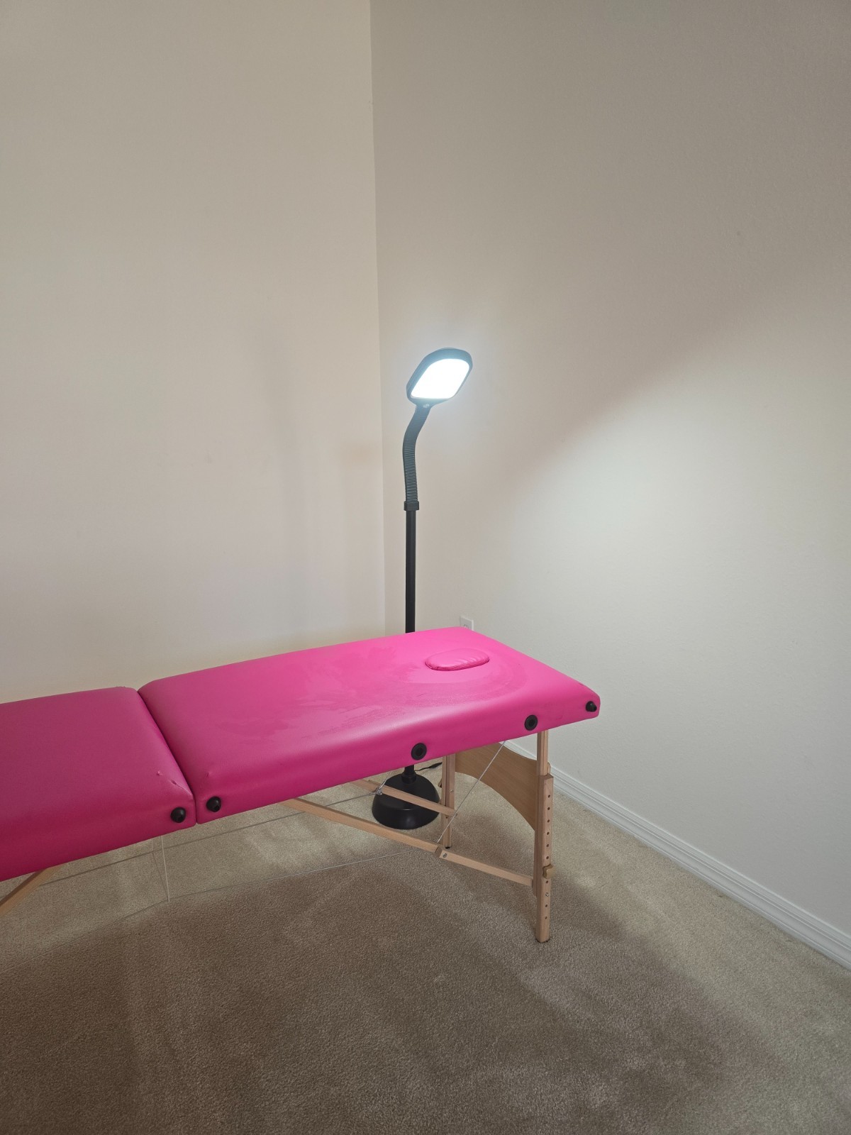 pink portable massage table with flexible lamp