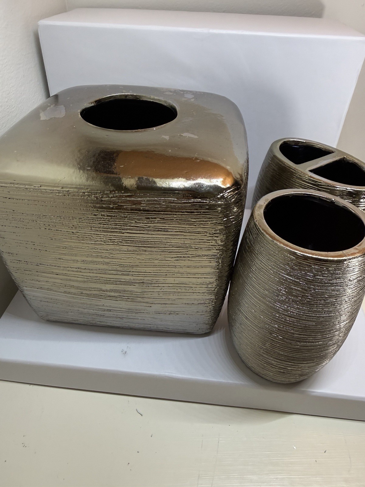 textured metallic home accessory set, possibly including a tissue box cover