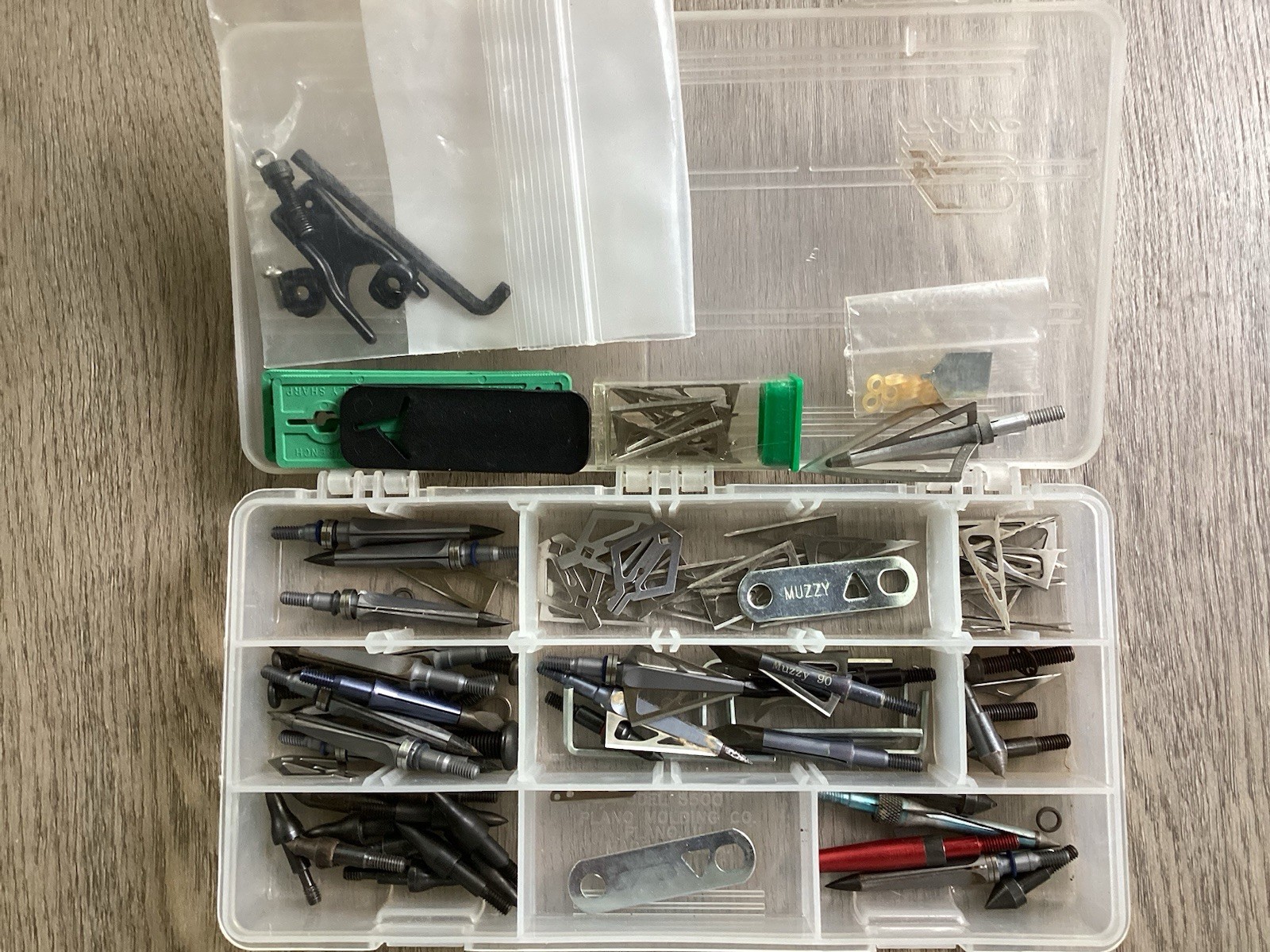 Assortment of archery broadheads,field tips,and other items.
