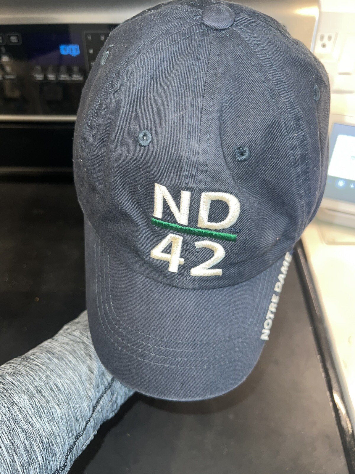 Notre Dame on billNavy blue Hat Cap with ND underlined in Green and 42 under Adj