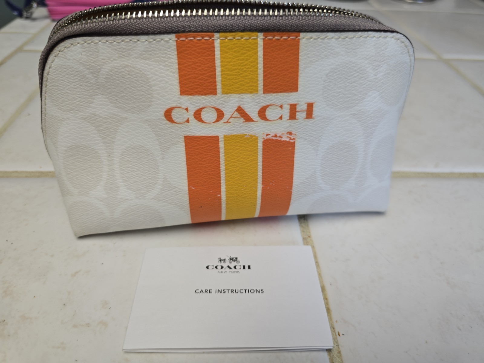 Coach Varsity Stripe Cosmetic Case in the "Chalk Orange" colorway.
