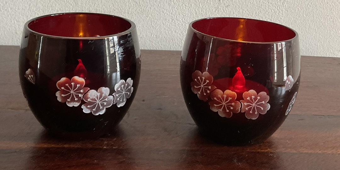 Pair Of Bohemian style red glass tea candle holder with floral engraving.