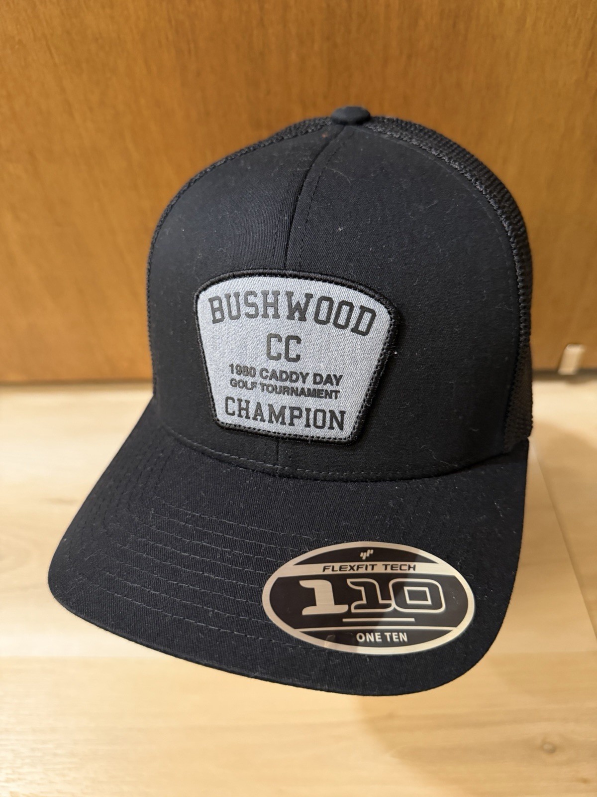 TravisMathew Presidential Suite Trucker Hat Black - Bushwood CC 1980 Caddy Day