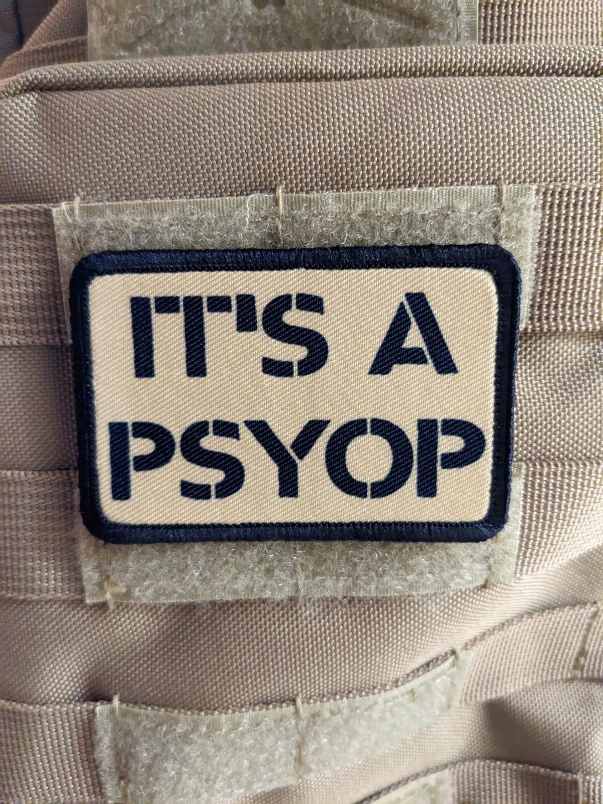 It's a Psyop conspiracy morale patch 2"x3" hook & loop tactical tan