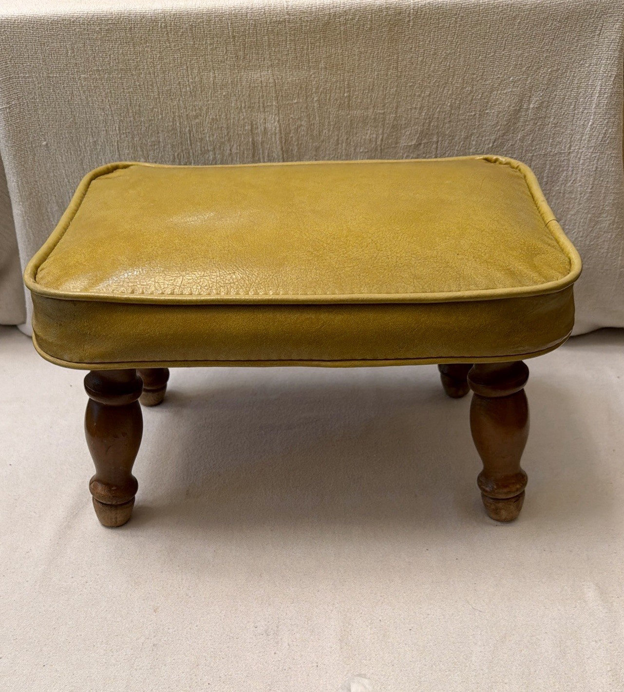 VINTAGE MCM FOOT STOOL. YELLOW VINYL W/ WOOD SPINDLE LEGS