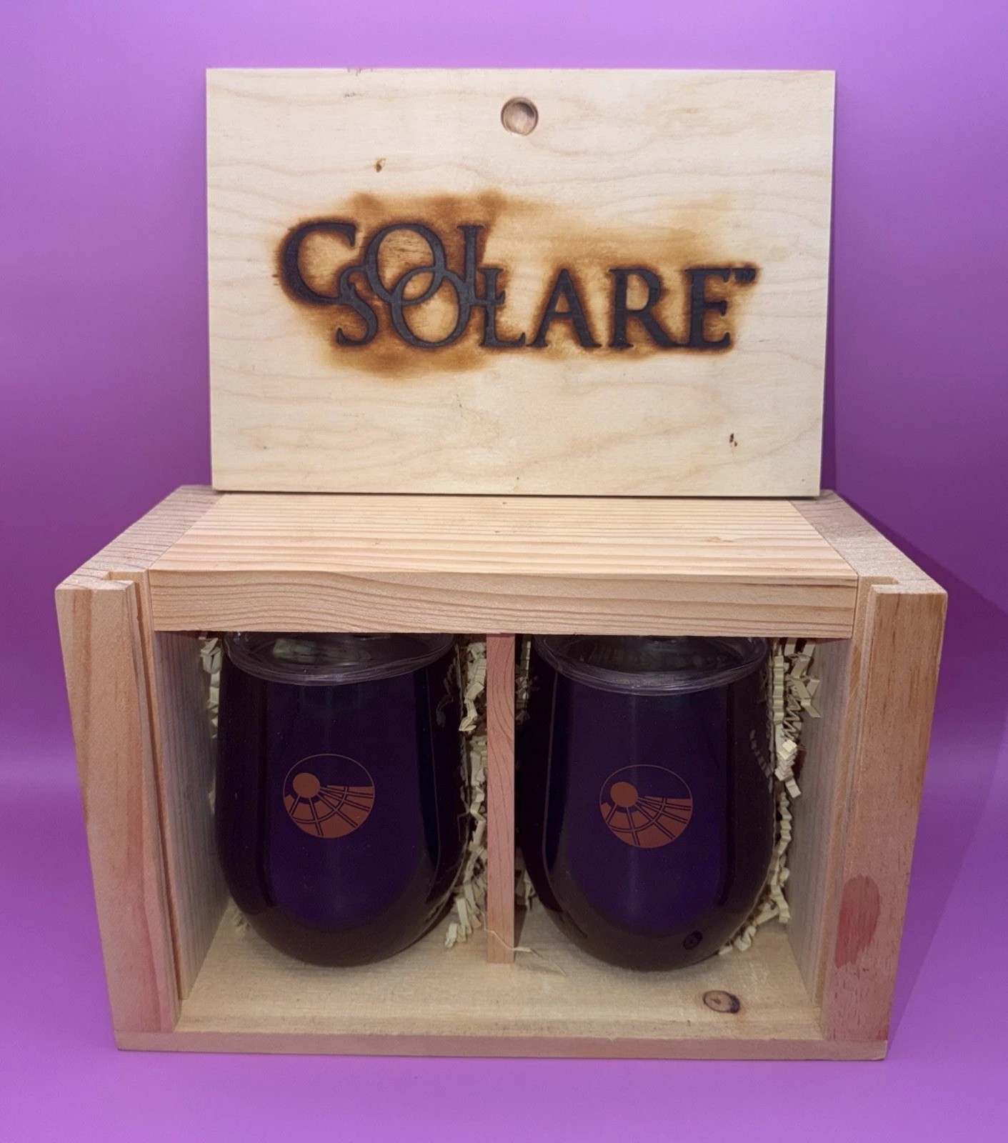 A Col Solare gift set features two deep purple stemless wine glasses, New.