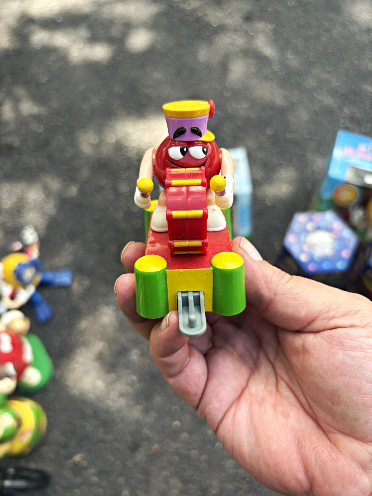 m&m's green character plastic toy figurine on red base w/ red green scooter