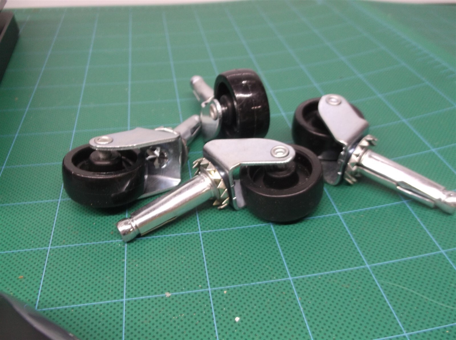 lot of 4 1-1/8" black casters with 25/64" diameter stems
