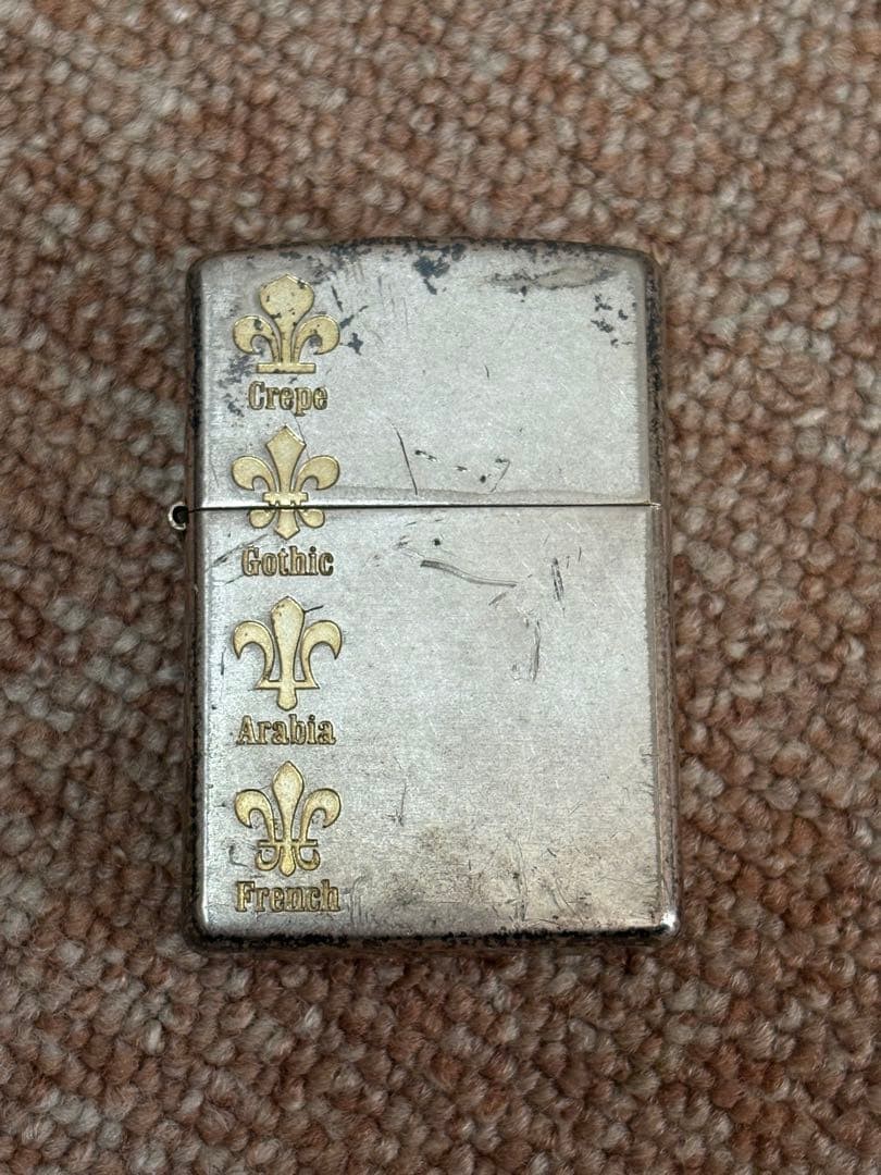 Zippo lighter with fleur-de-lis decoration and serial number