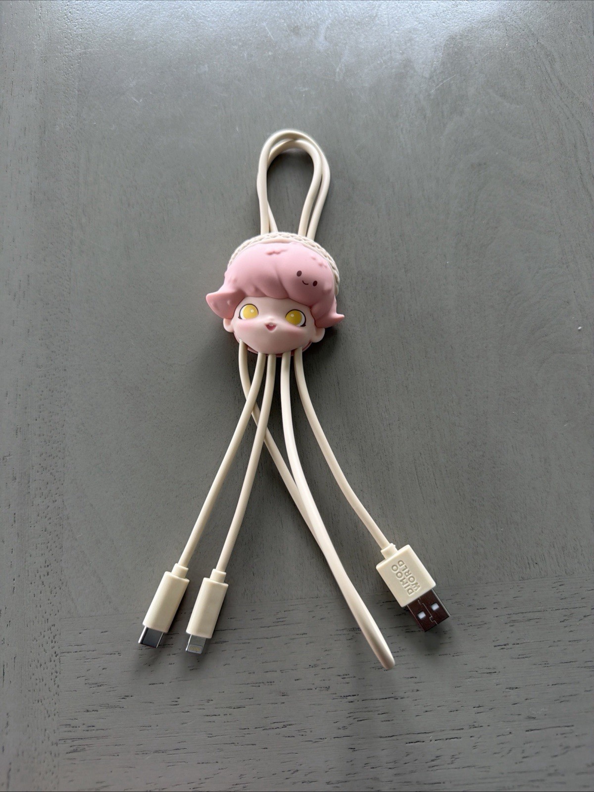 This is a Pop Mart DIMOO World series cable, part of a collaboration with Disney