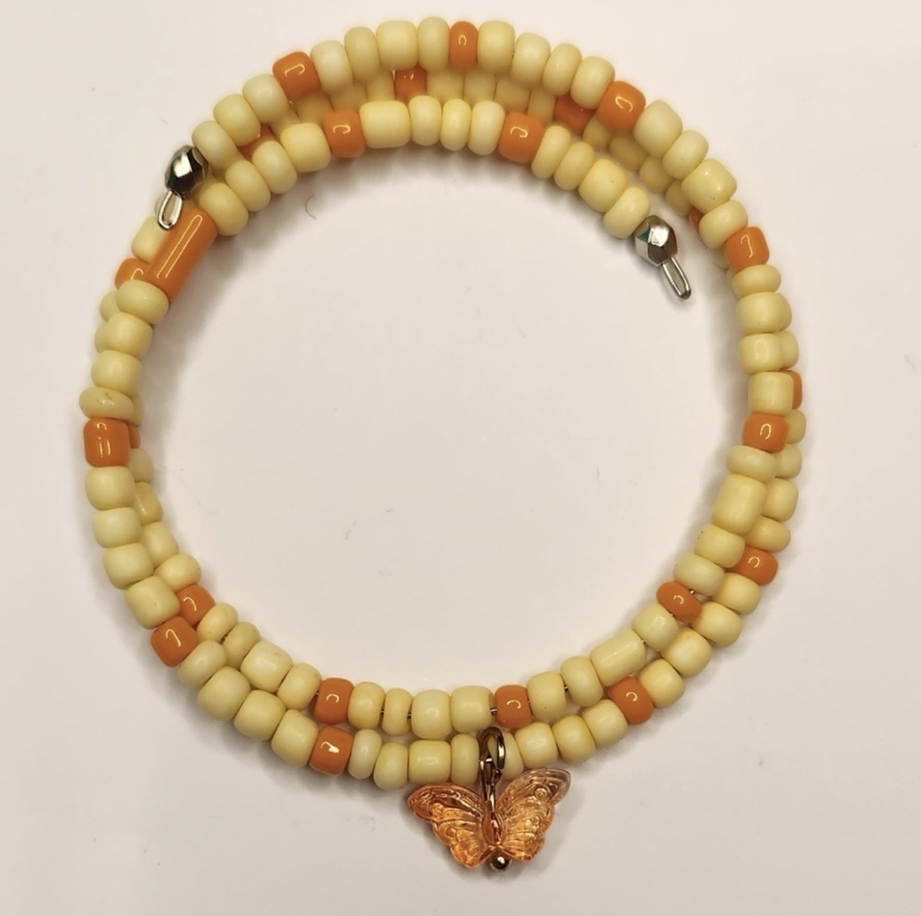 Cream orange beaded glass bracelet with butterfly dangle charm, round beads