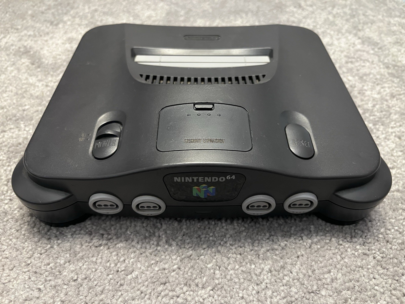 Nintendo 64 with black controller, AV cables, and power supply.
