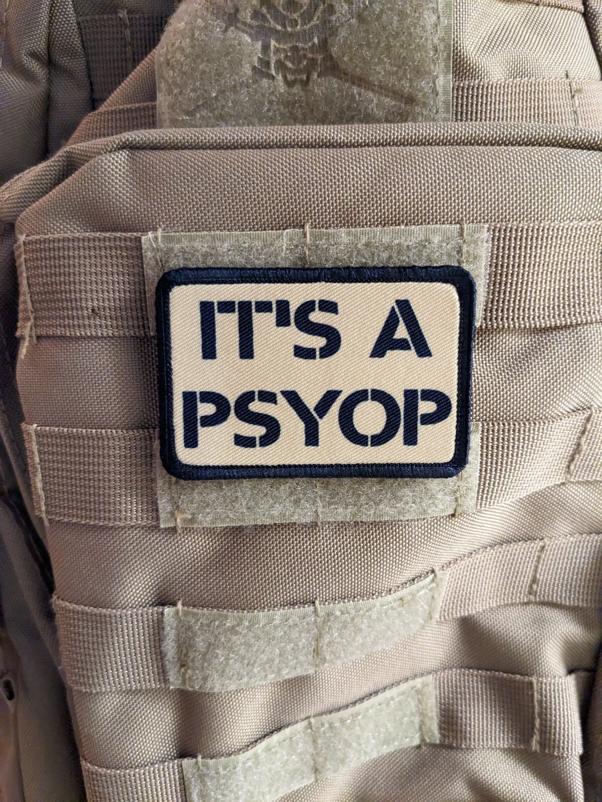 It's a Psyop conspiracy morale patch 2"x3" hook & loop tactical tan