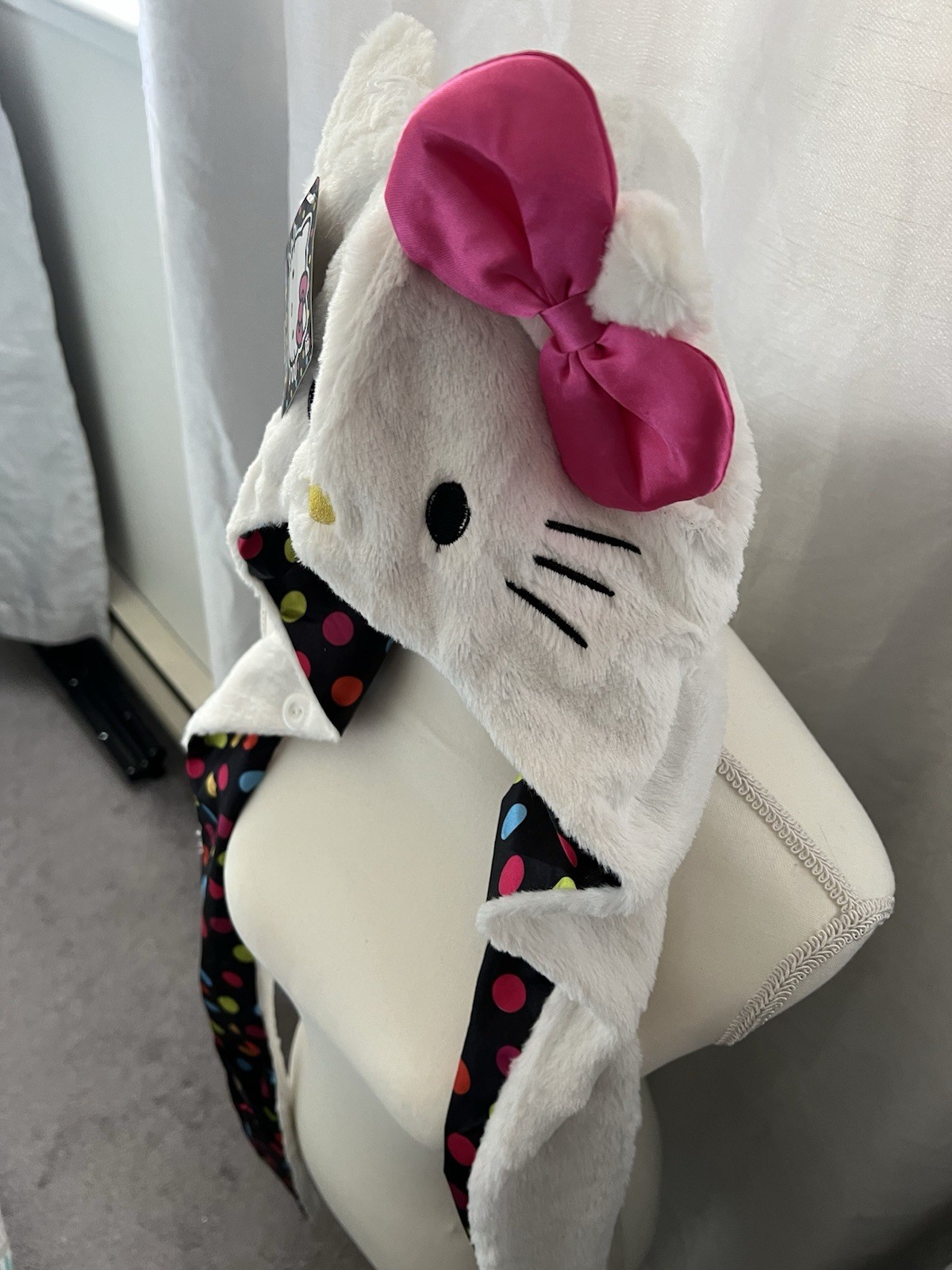 Hello Kitty Hat Hood in white with a pink bow and a polka dot lining.