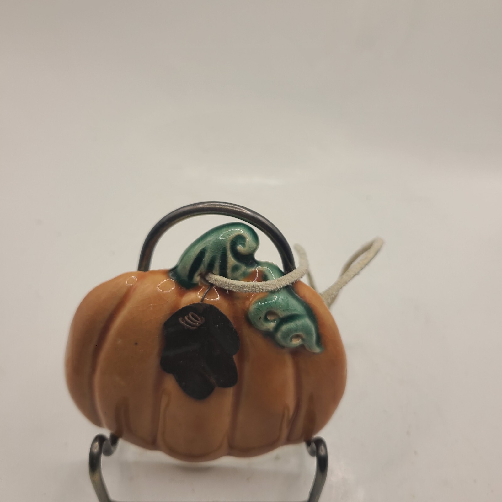 Ceramic pumpkin ornament with leaves. One leaf metal.