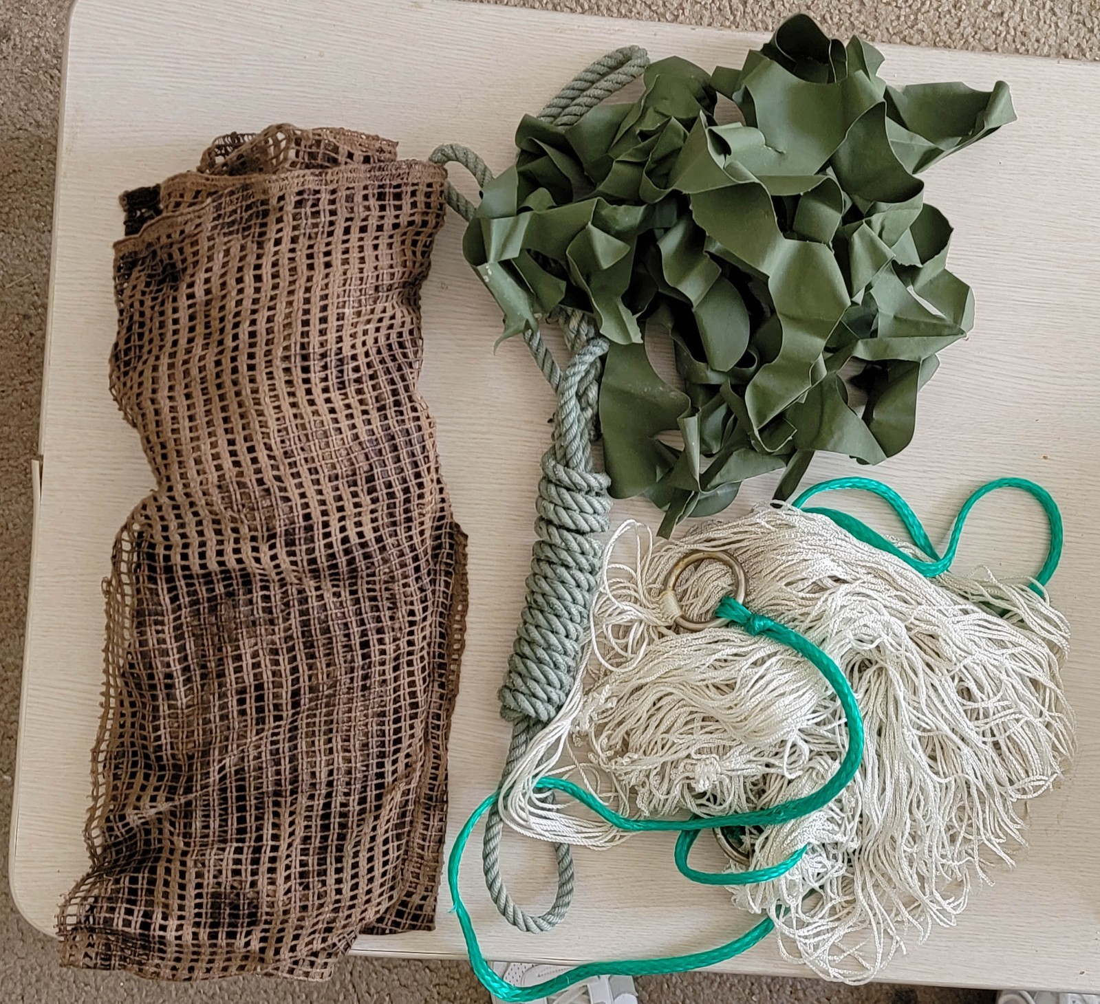 Group of US soldiers survival field gear, rope, hammock, and camo veils.